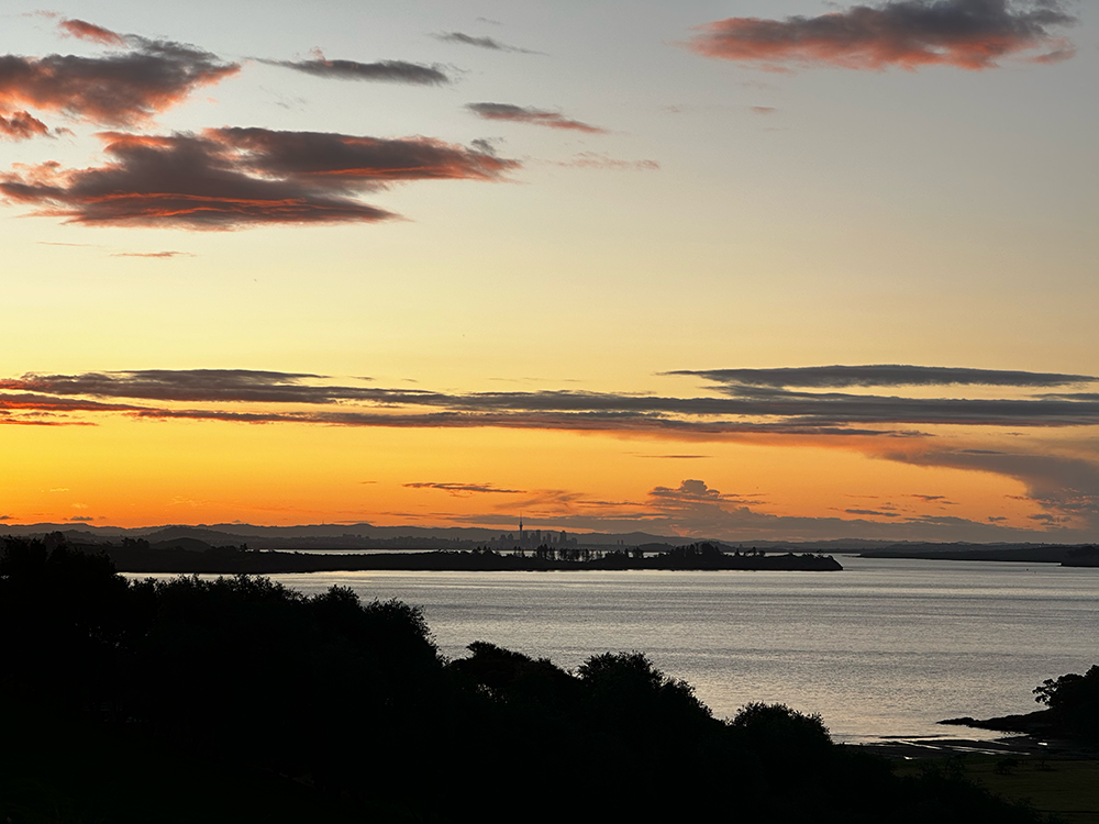 Photo of a glorious sunset of a cityscape seen from across a bay