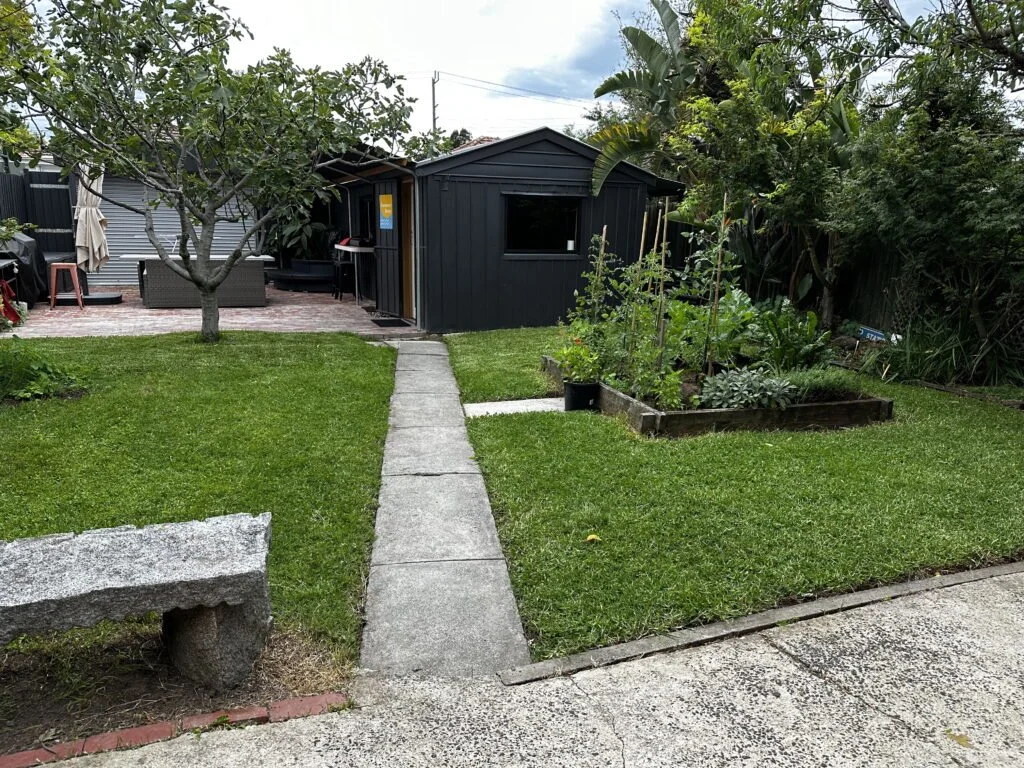 Photo of a homely backyard with a lawn and garden path