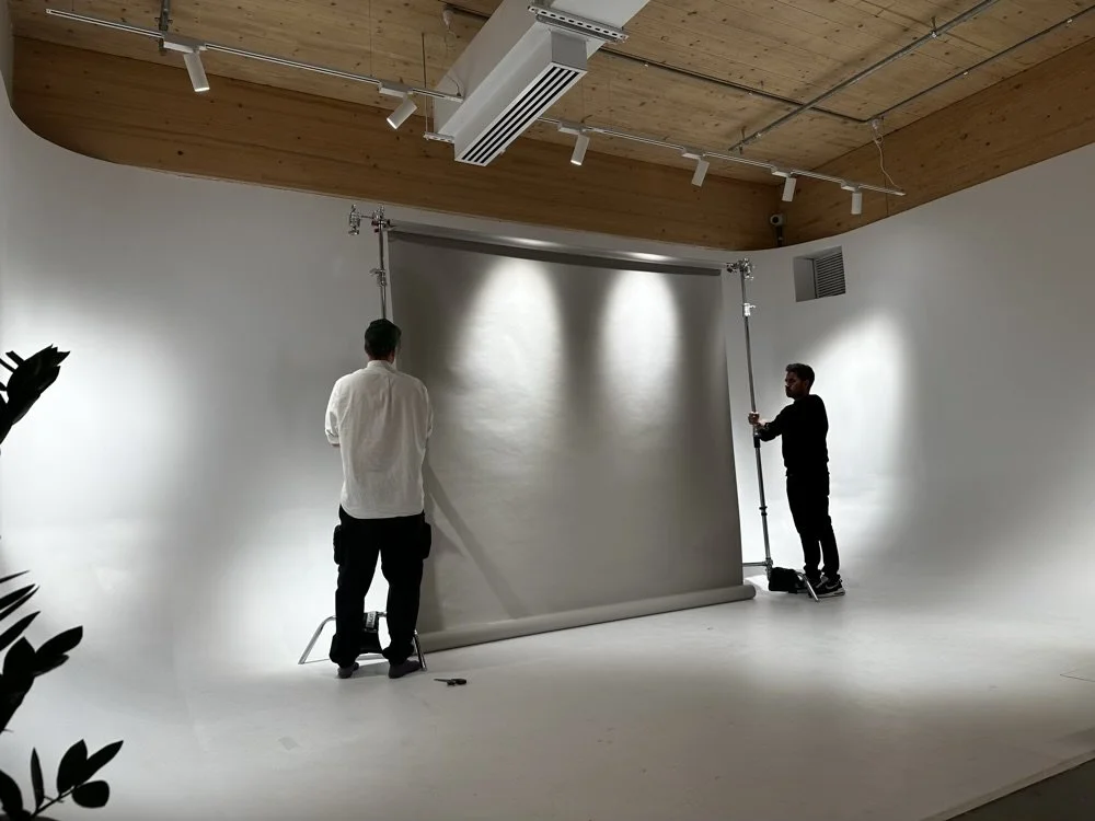 Two photographers setting up a backdrop for a photoshoot