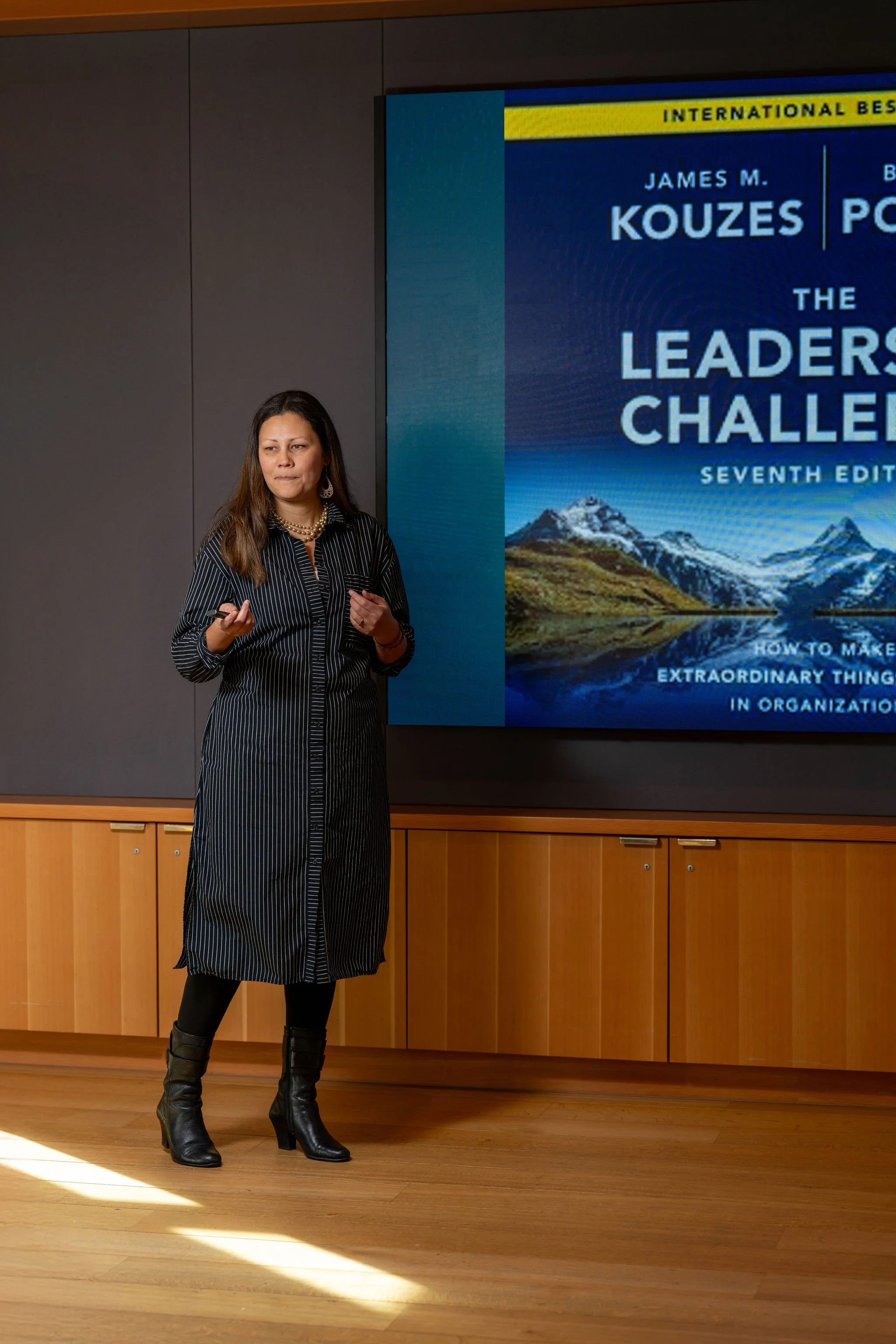 Photo of Hannah presenting in front of a PowerPoint on a screen.
