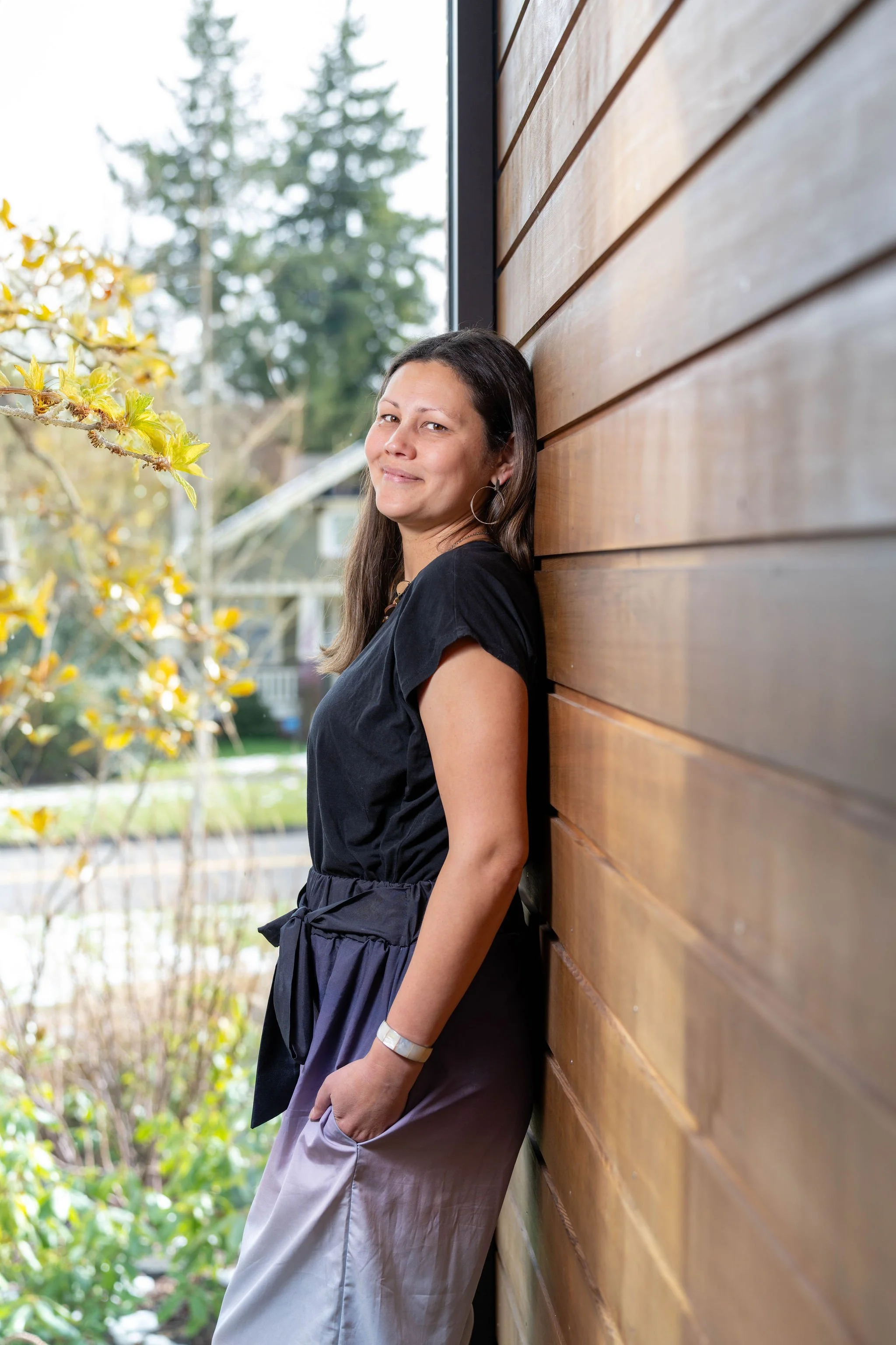 Photo of Hannah smiling and leaning against a wall.