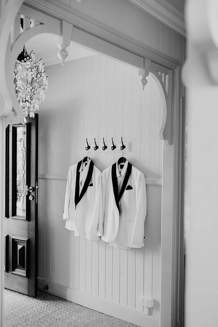 A photo of two white tuxedo jackets in a wedding by Lee Burgess from Love and Life Photography
