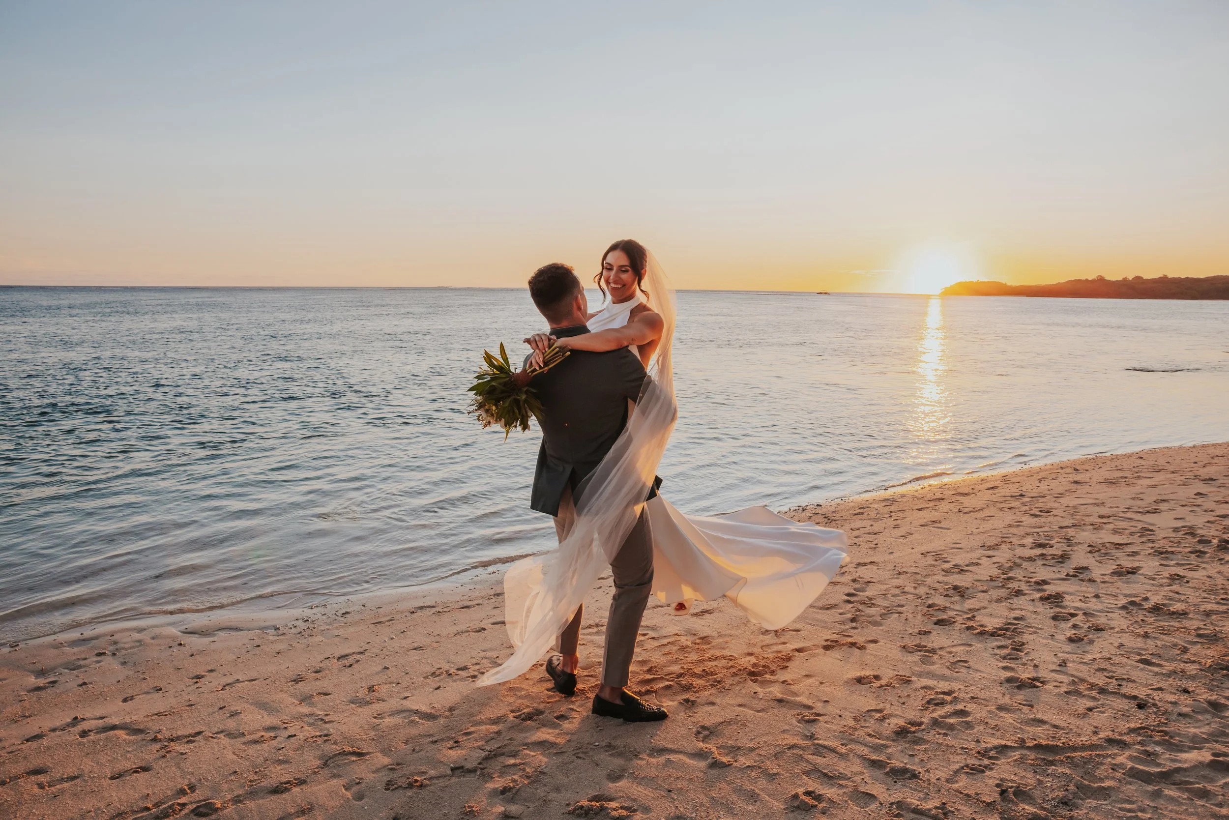 Bride and groom on the beach during sunset wedding photo by Lee Burgess from Love and Life Photography 