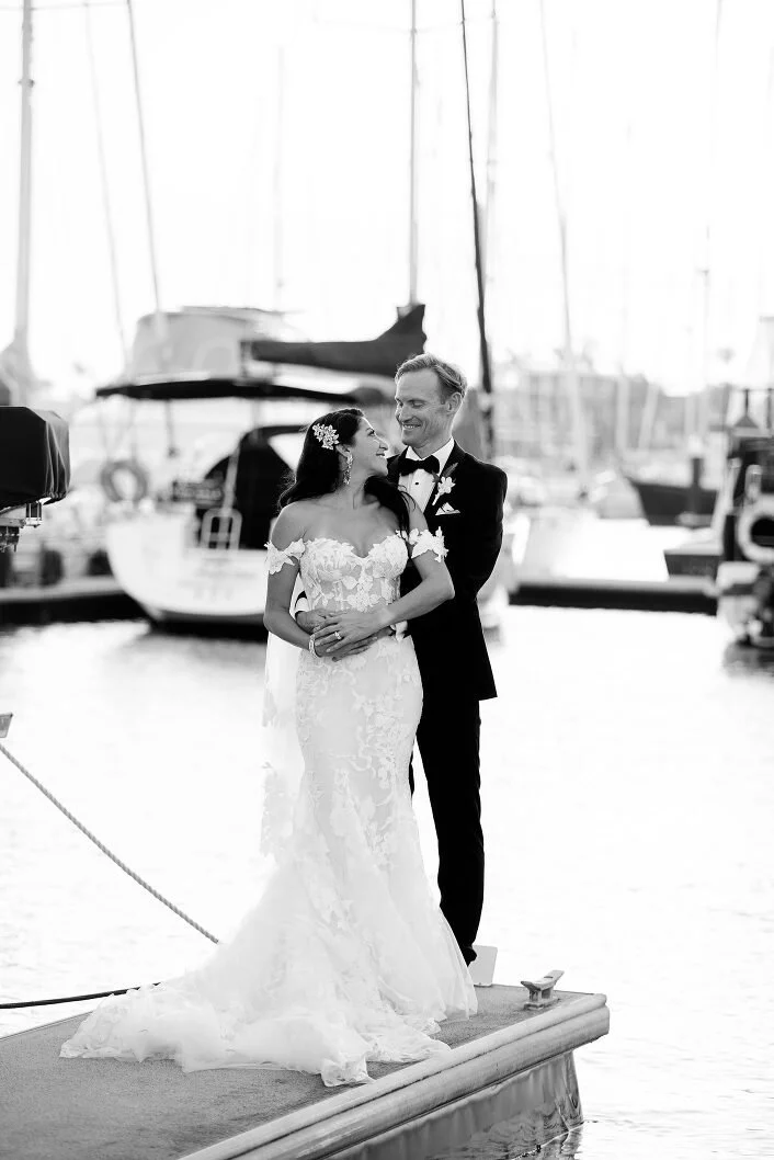 A photo of a couple stands on a dock by the water by Lee Burgess from Love and Life Photography 