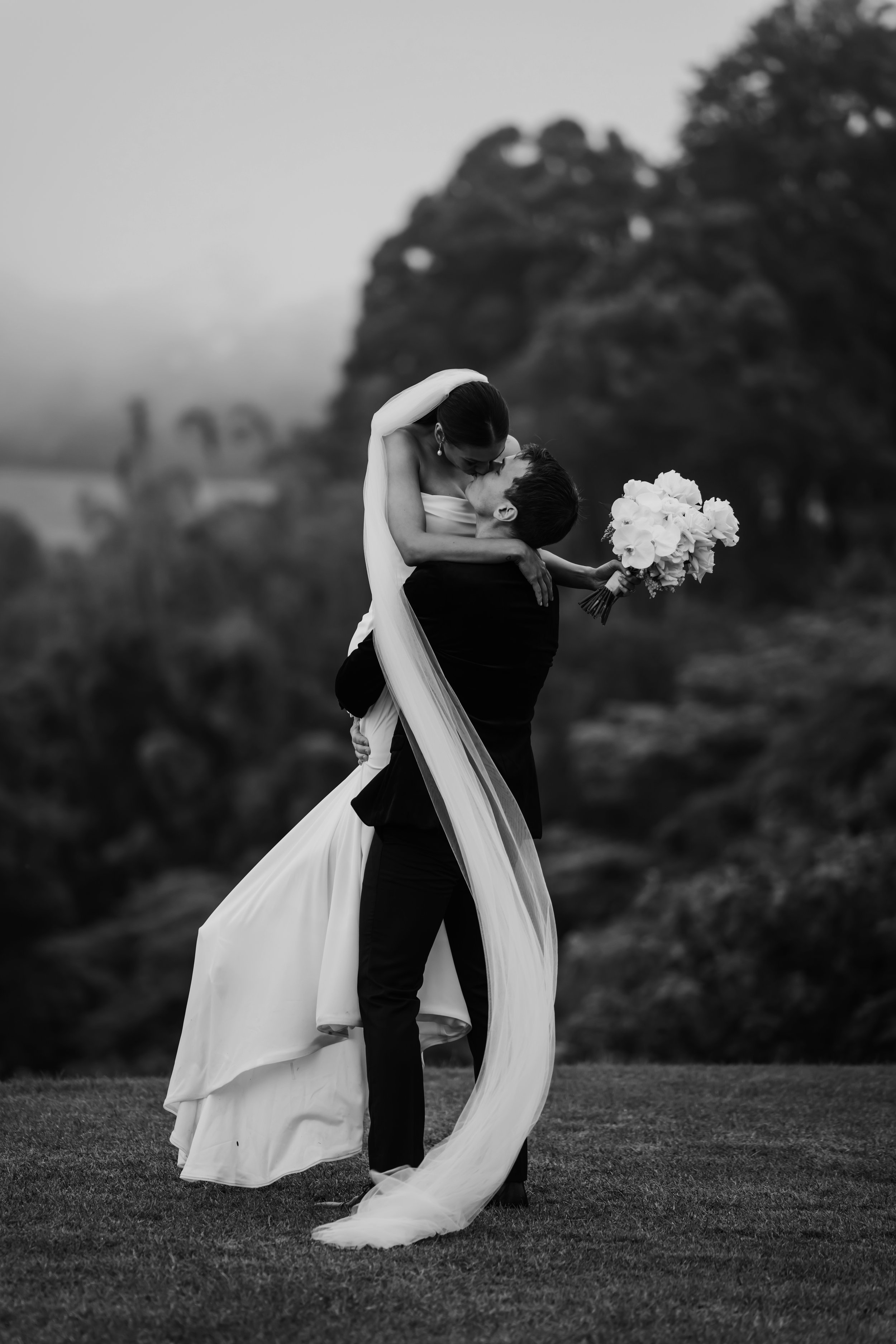 A black and white photo of a bride and groom outdoors by Lee Burgess from Love and Life Photography 