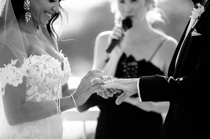 A photo of a bride and groom exchanging wedding rings during their ceremony by Lee Burgess from Love and Life Photography 