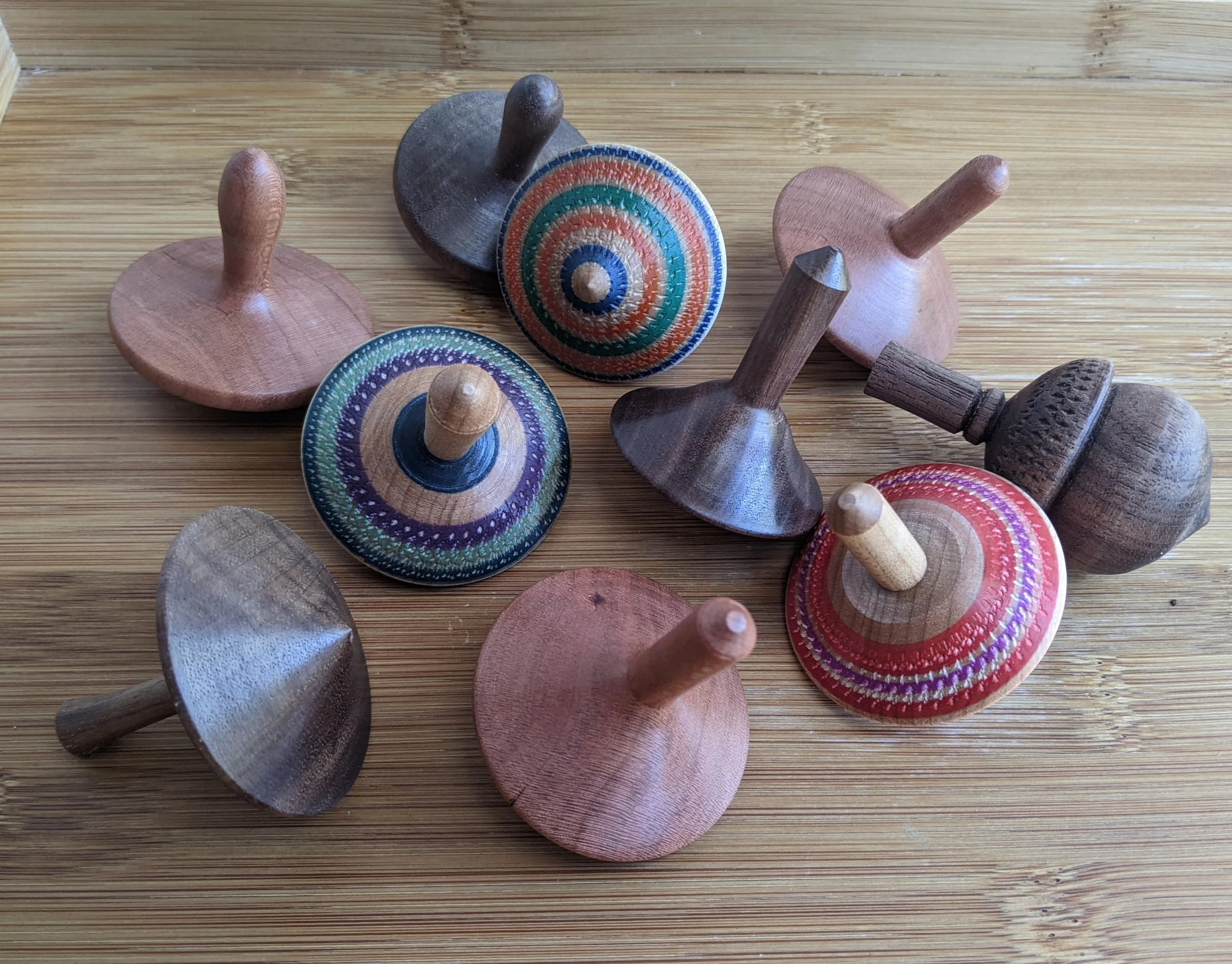 multiple wood spinning tops varying in material and color