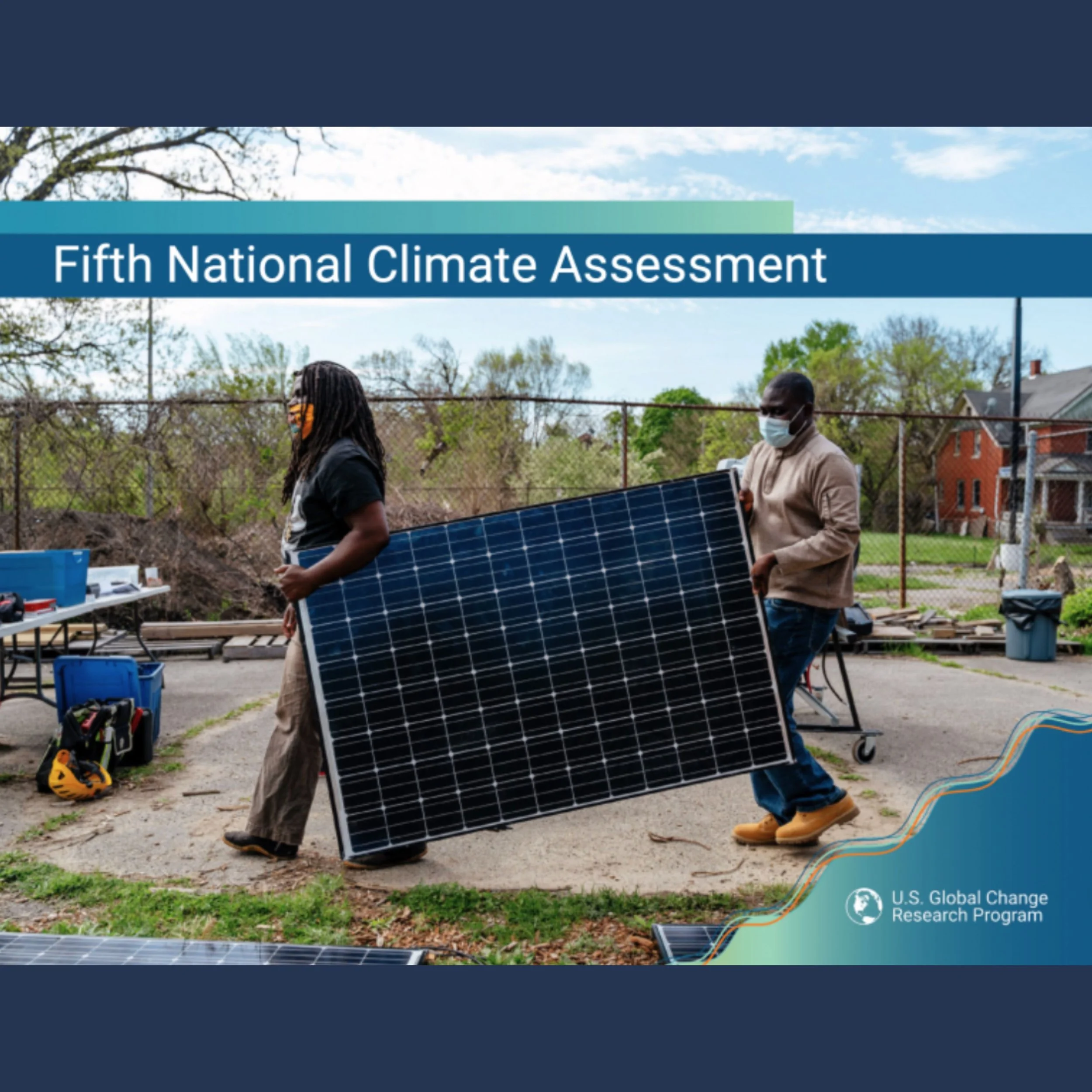 People working outdoors on solar panels during the Fifth National Climate Assessment, wearing masks with trees and houses in the background.