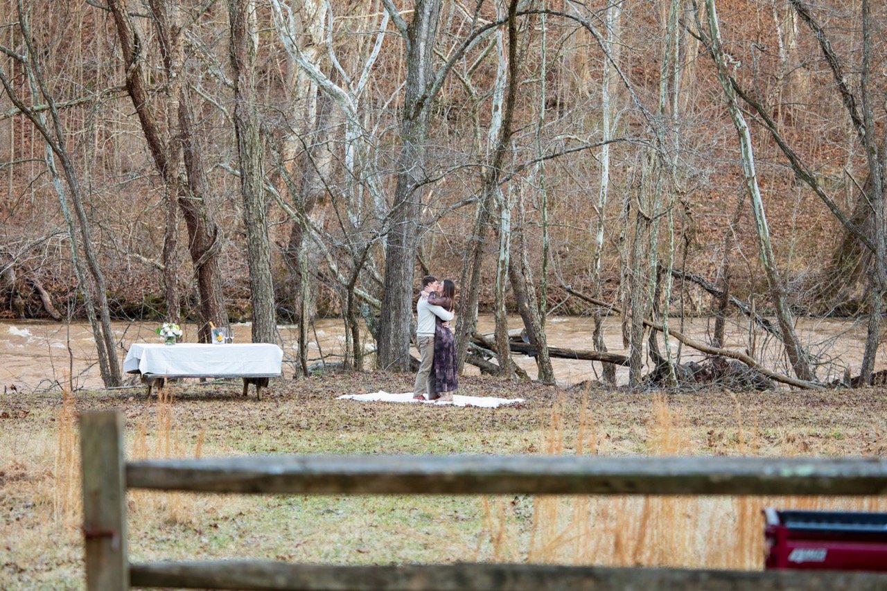 An intimate candid moment of a newly engaged couple holding hands at their outdoor proposal site in NoVA.