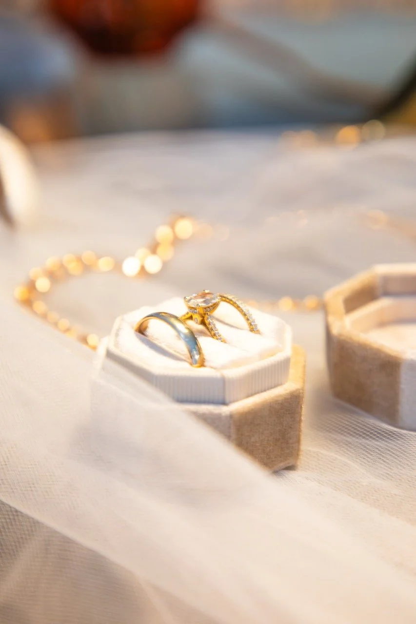 Close-up macro shot of gold wedding bands nestled in a velvet ring box at a Hampton Roads wedding.
