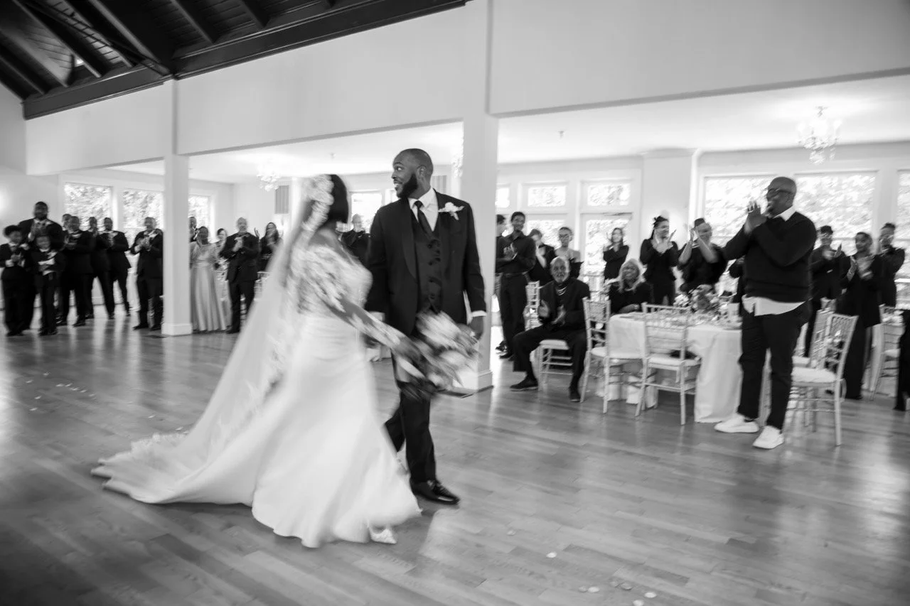 Newlyweds Kareese and Tristan smile as they walk back down the aisle at the Woman's Club of Portsmouth, captured by a Hampton Roads wedding photographer.