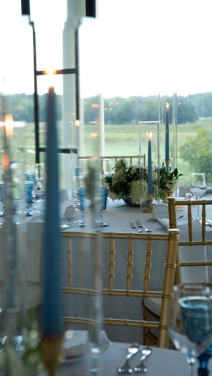 Bright reception table styling with blue glassware, lush white roses, and gold details for a Virginia rehearsal dinner.