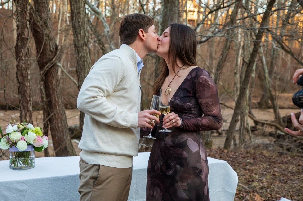 Caroline and Clay pouring glasses of champagne to celebrate their engagement in Richmond, VA.