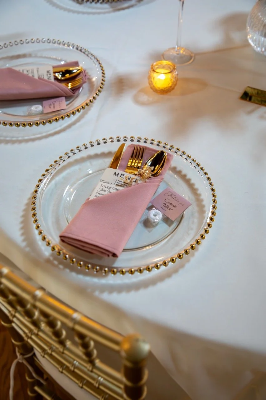 Elegant gold and pink wedding place setting with menu card details at a 7 Cities wedding venue.