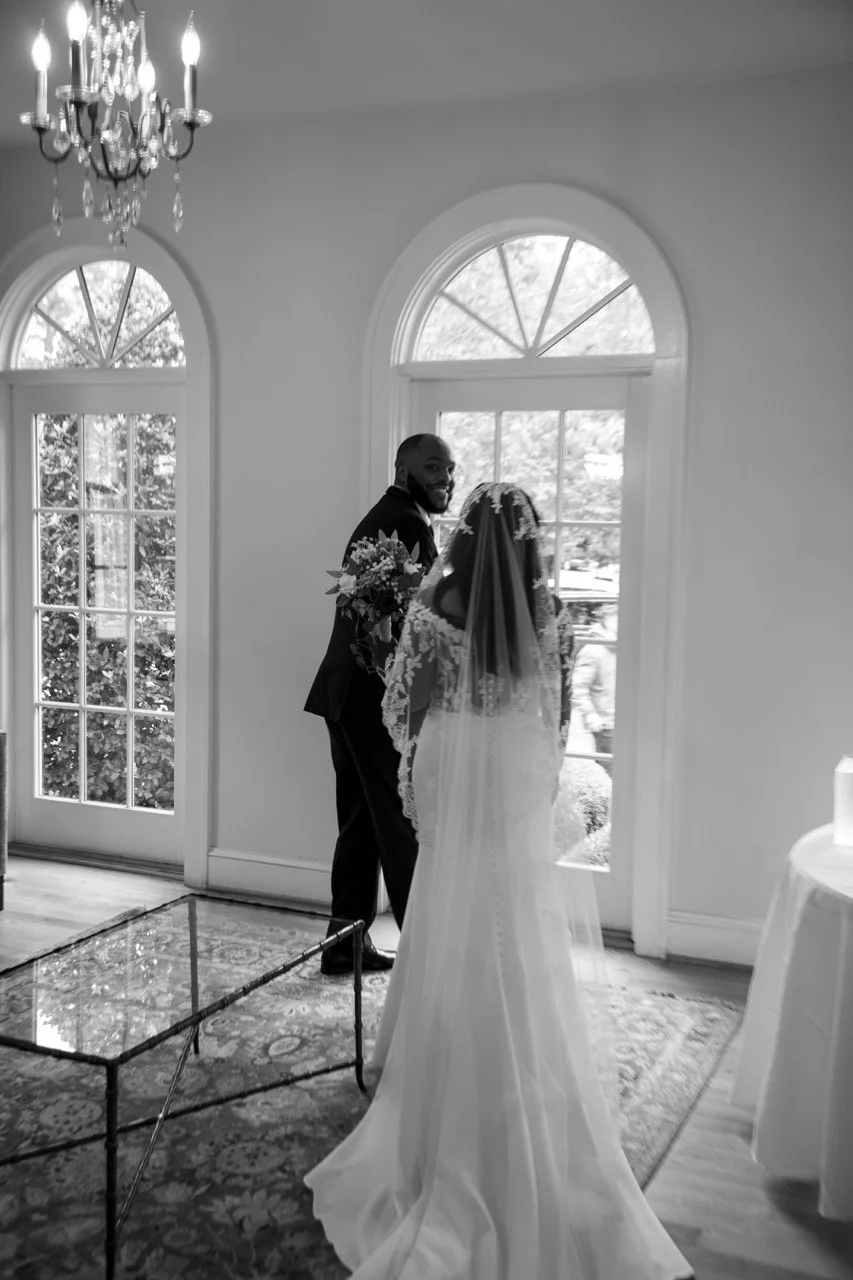 Emotional wedding first look moment by the large arched windows at the Woman's Club of Portsmouth.