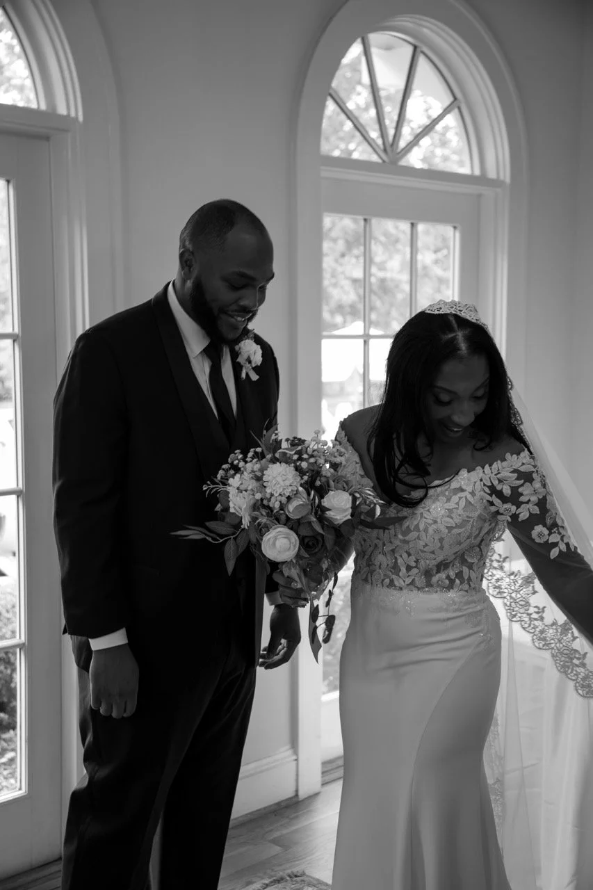 The bride and groom admire her beautiful wedding bouquet together at the Woman's Club of Portsmouth.