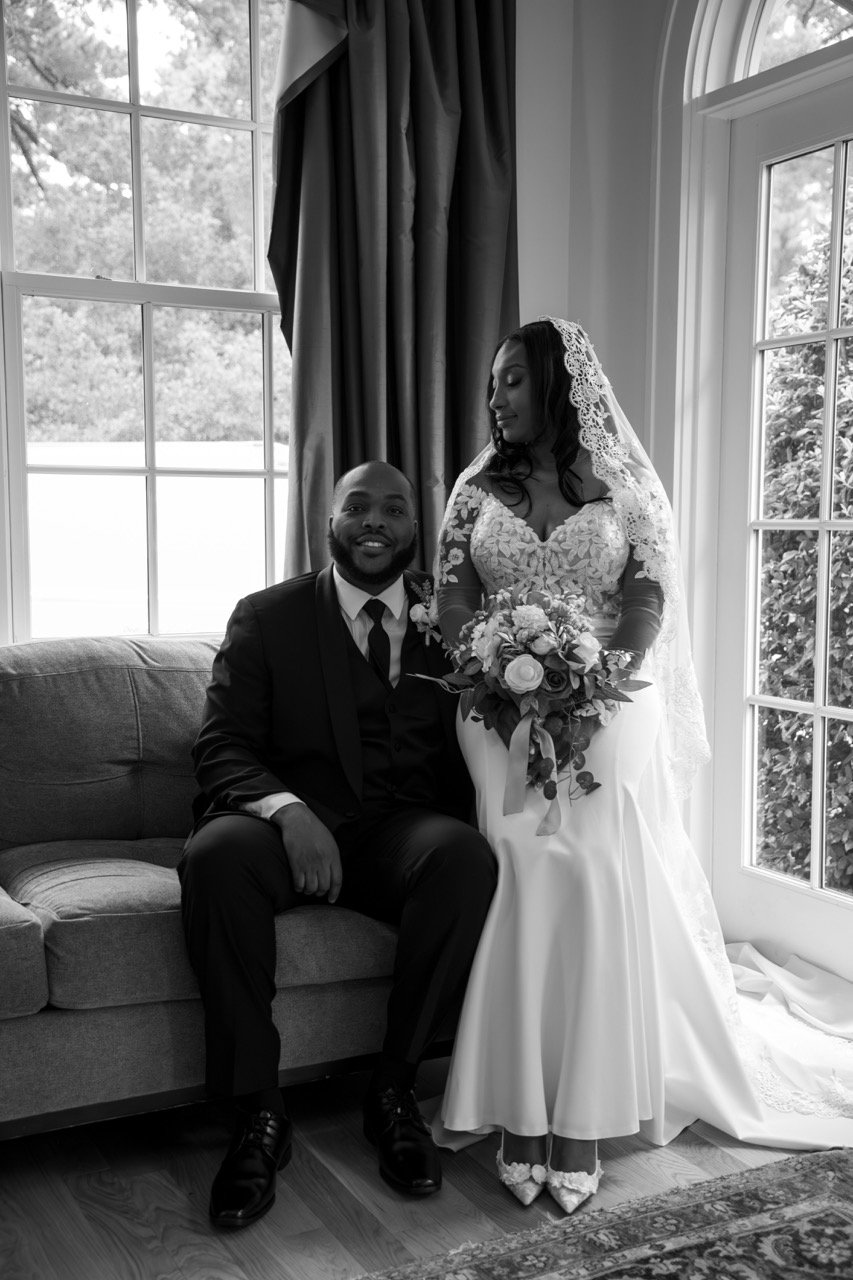 Kareese and Tristan smiling together while seated near a window on their wedding day in Portsmouth, Virginia.