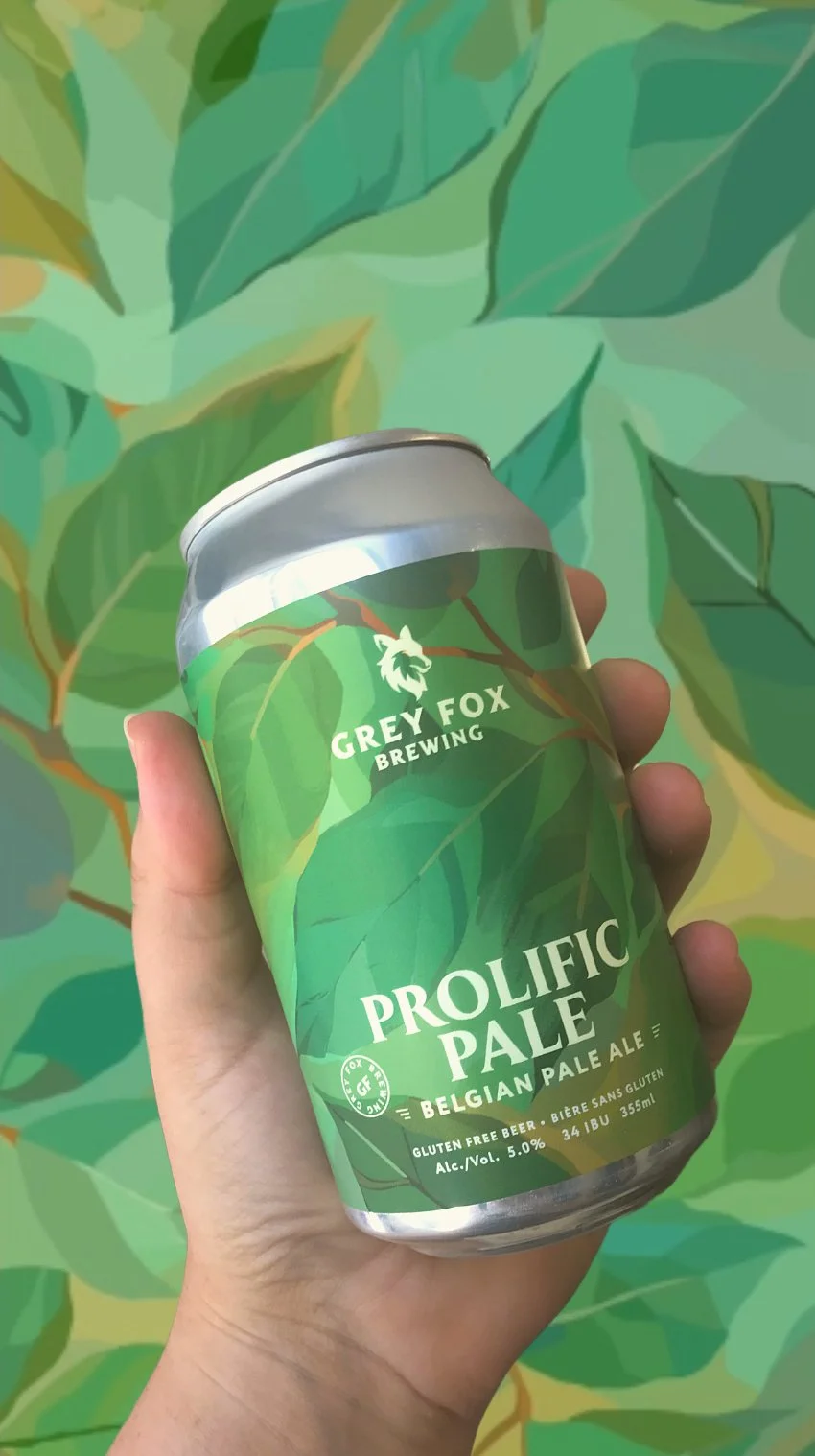 A hand holding a can of Grey Fox Brewing Prolific Pale Belgian Pale Ale with a green leafy background design.