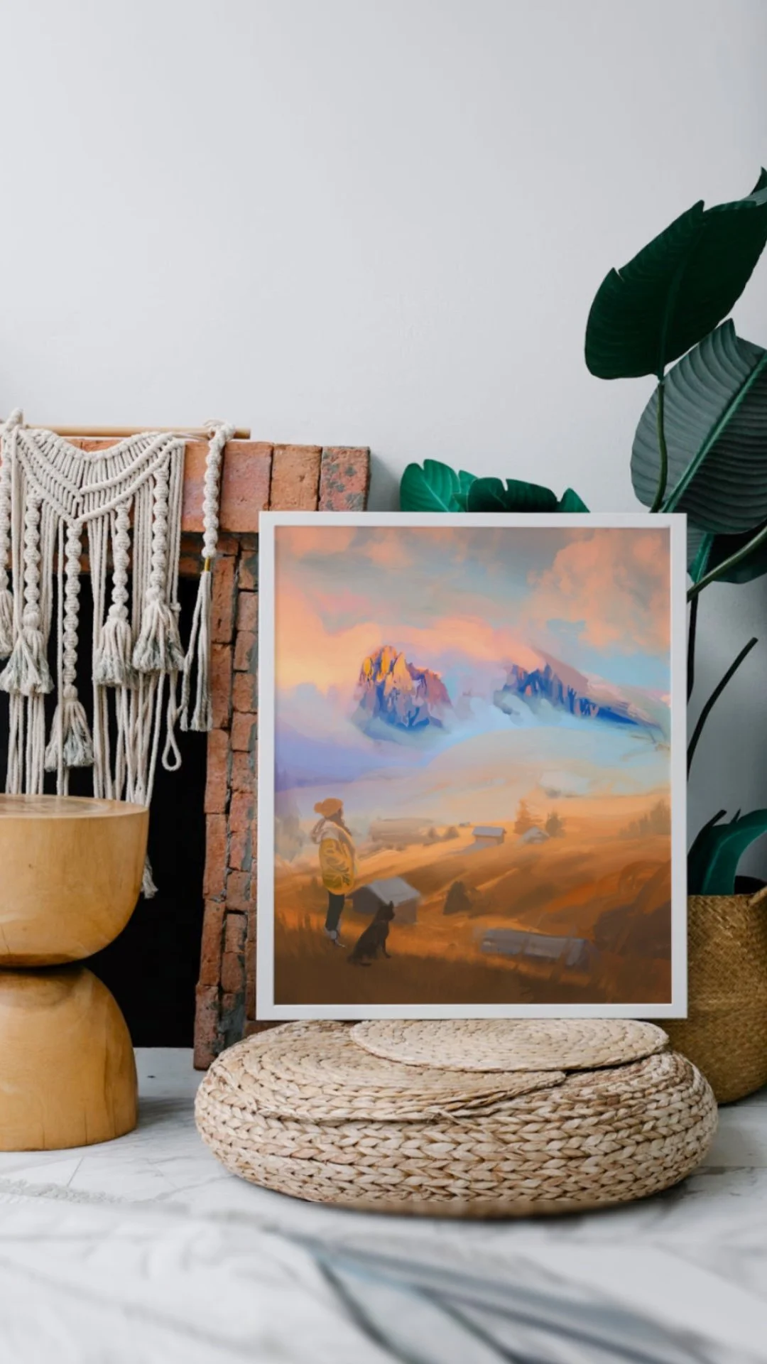 A colorful landscape painting of mountains, a person and a dog, set on woven mats surrounded by plants, a brick wall, and bohemian decor.