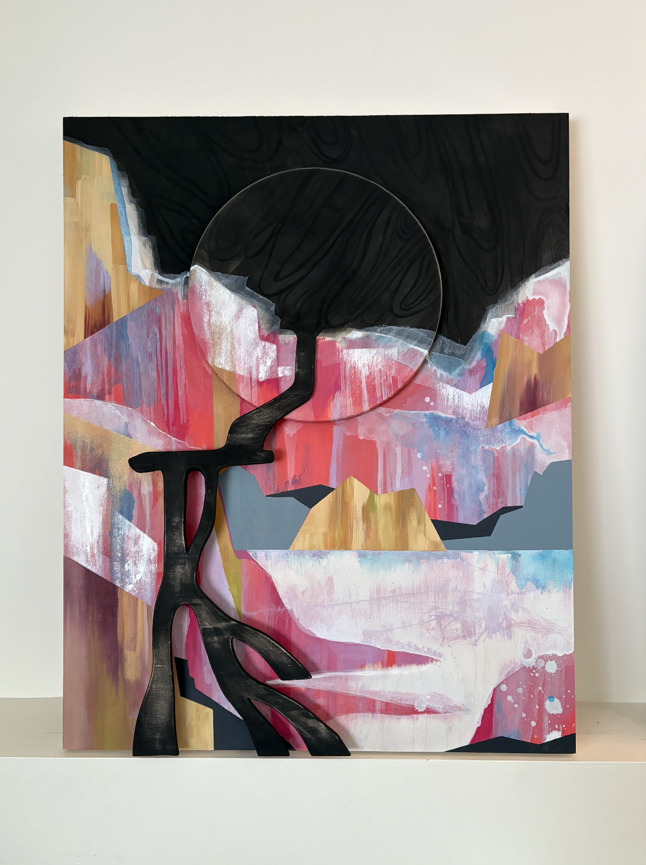 Abstract painting with black tree silhouette in front of a colorful mountainous landscape, waterfall, Iceland, featuring pink, white, blue, and beige hues, with a black circle at the top. Kelowna BC. Liz Grace Studio, Liz Dumontet