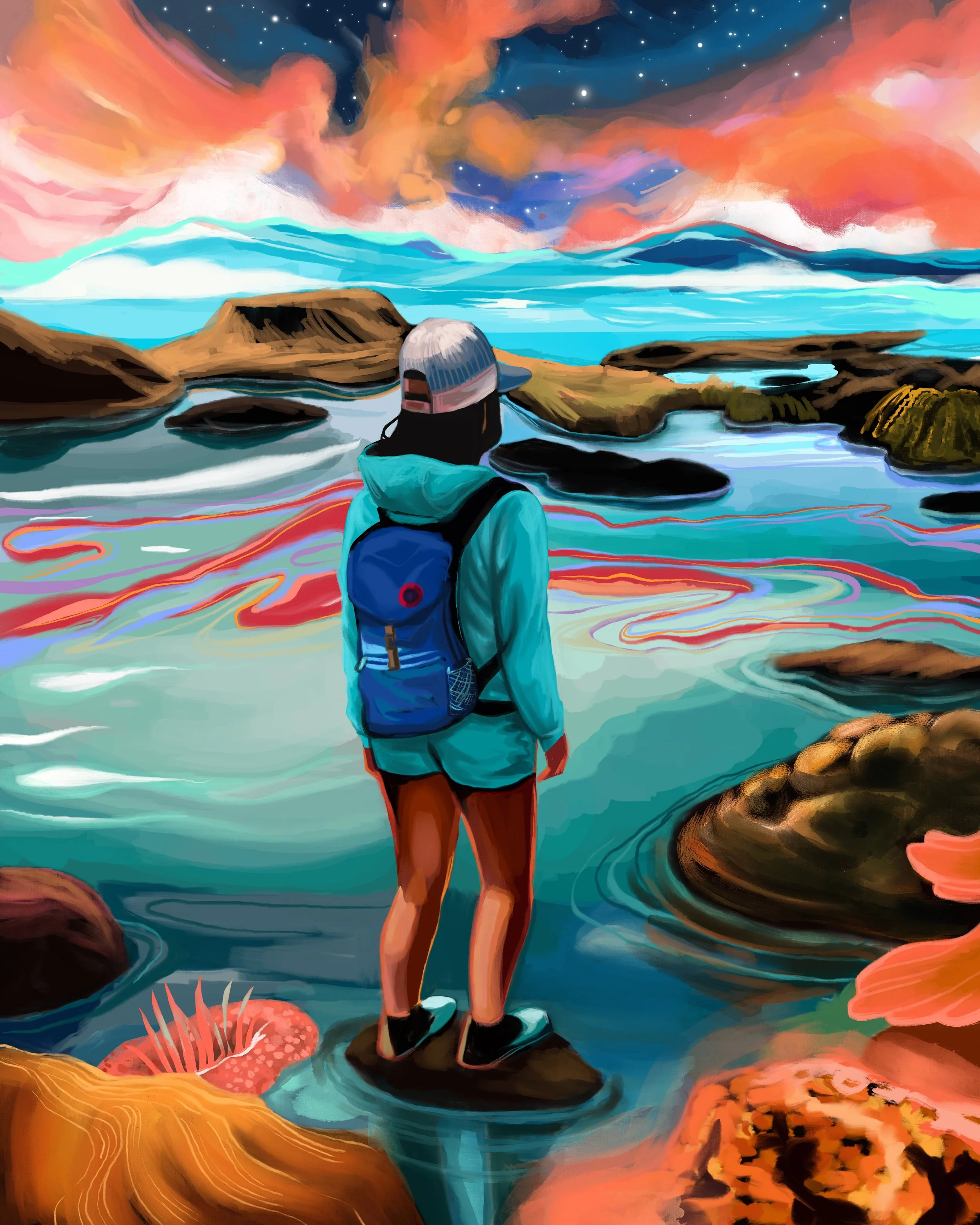 A person standing on rocks near the ocean, looking at a vibrant sunset with colorful clouds, rocks, and waves in the background.