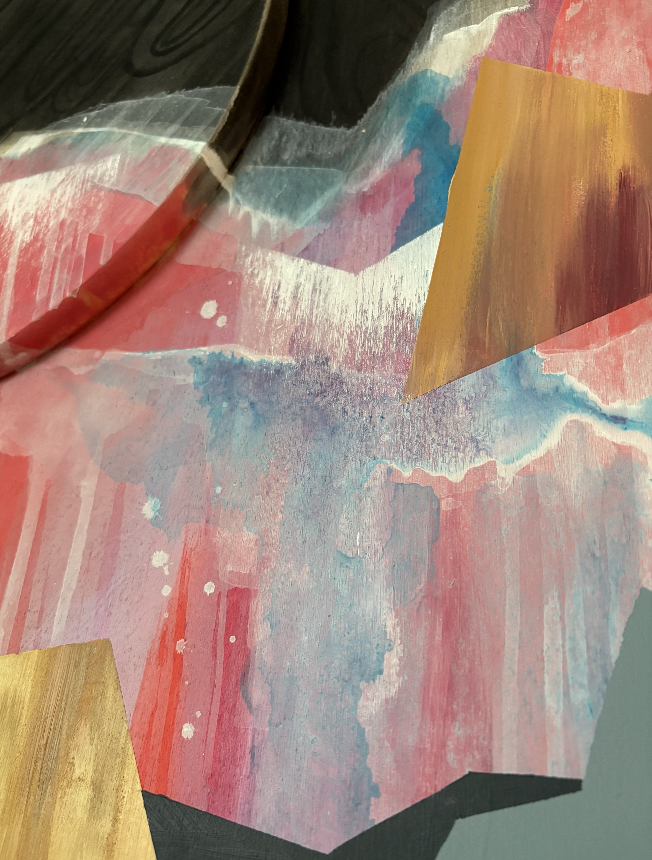 Close-up of an abstract painting with pink, blue, black, and gold watercolor effects and geometric shapes.