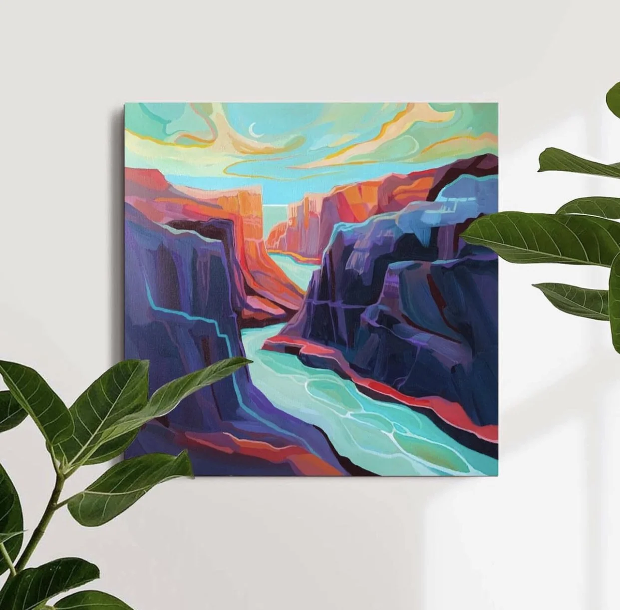 Colorful abstract painting of a canyon landscape with a river, set on a white wall surrounded by green plants.