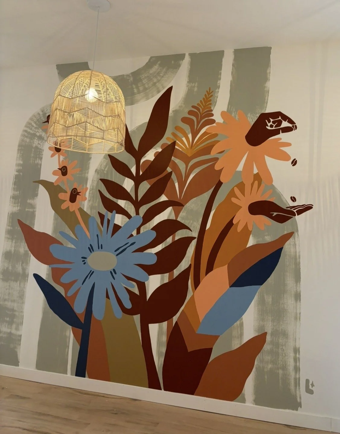 Wall mural of colorful abstract flowers and leaves in earth tones with a hanging woven lampshade