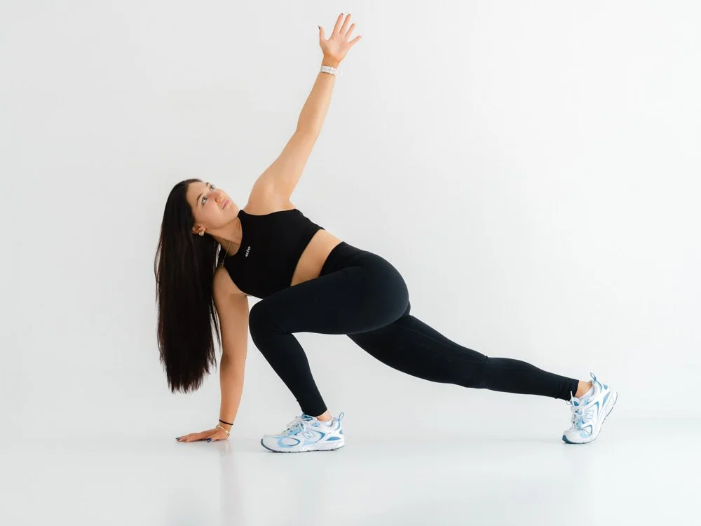 Woman doing a side plank exercise against a white background.