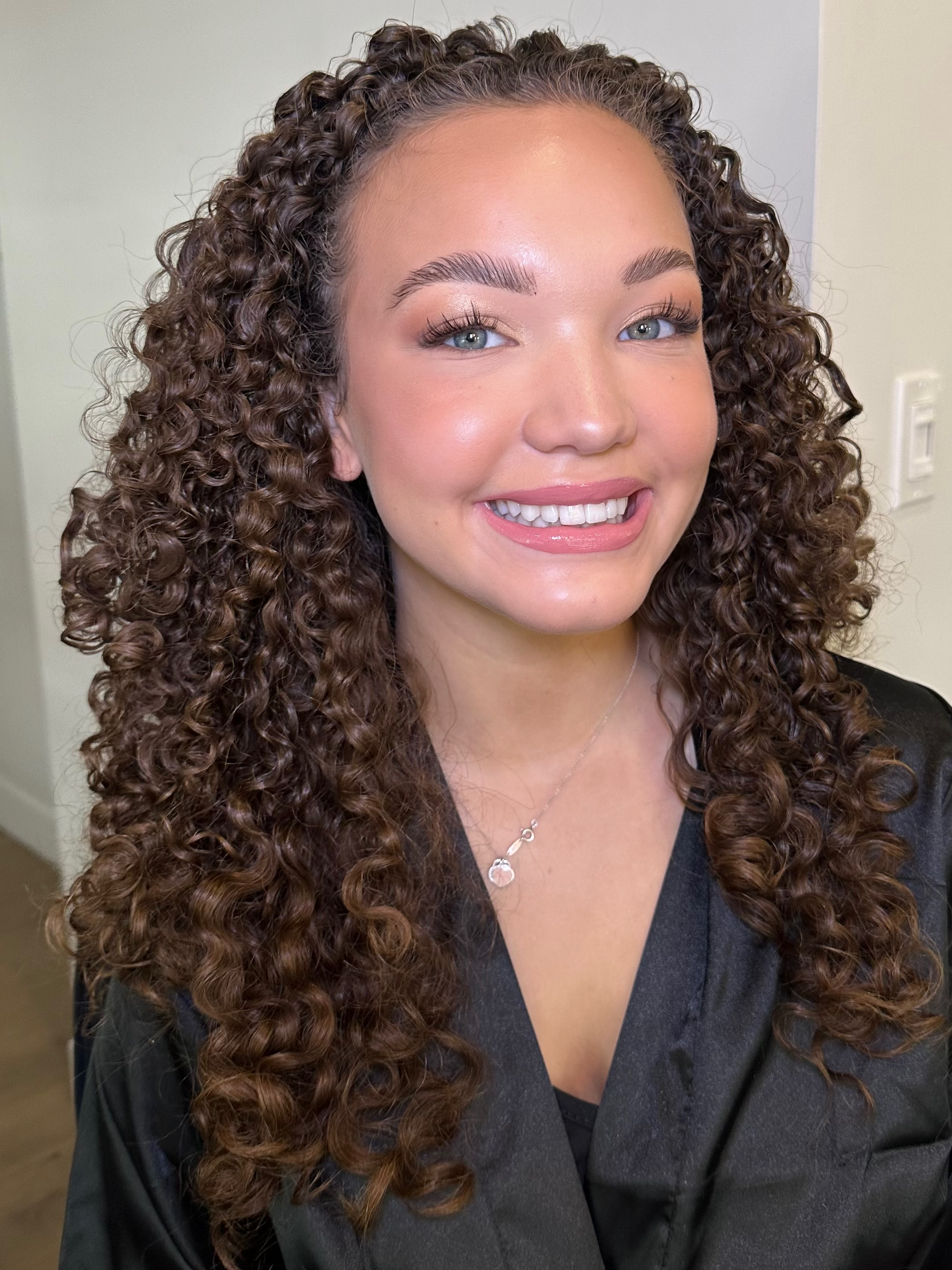 Natural glam makeup enhancing curly hair and radiant skin by Gloss & Glow Beauty Co., luxury makeup artist serving Maple Ridge and the Fraser Valley.