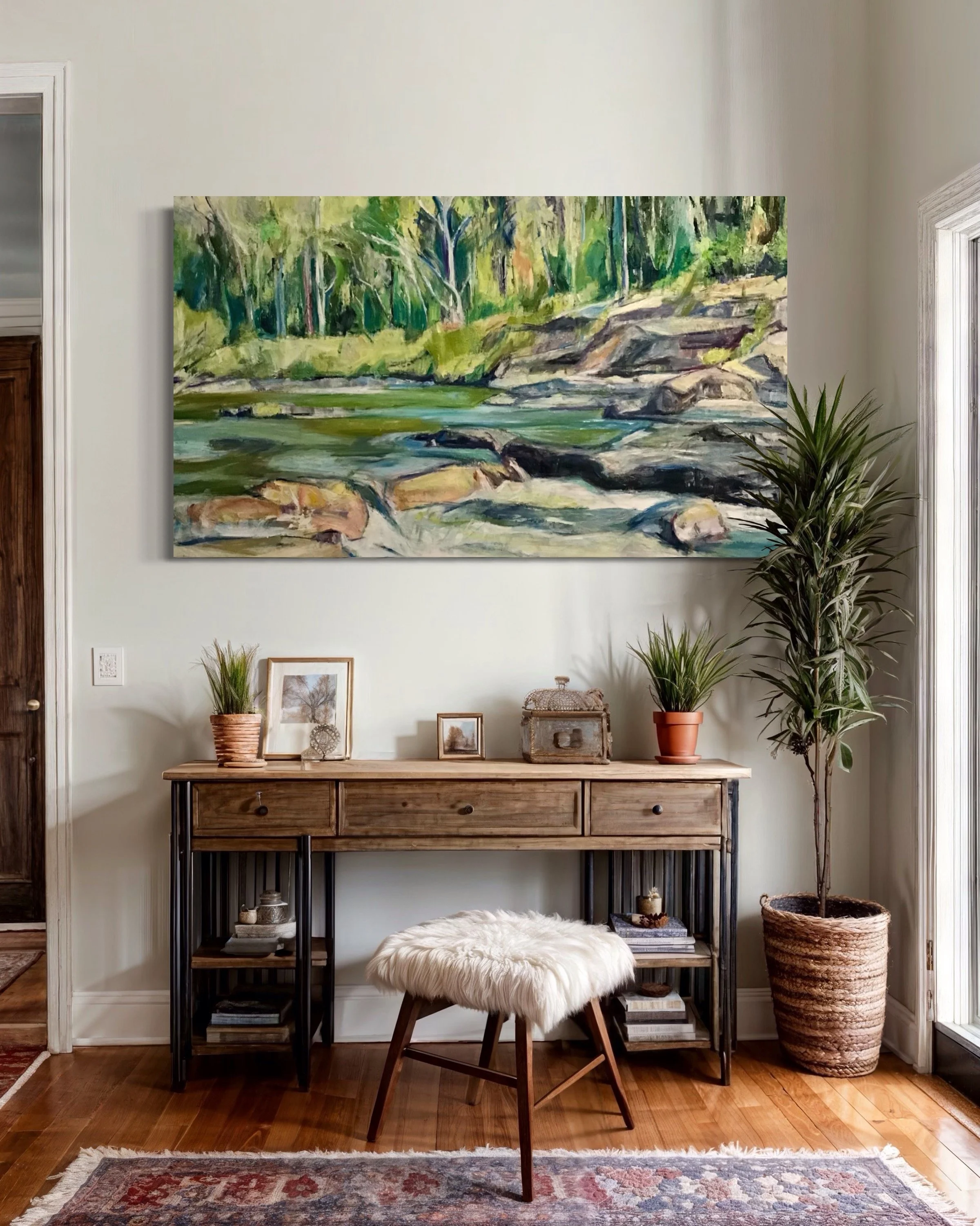 Vlad Kolas painting Living room corner with a framed painting of a river and trees hanging on a white wall, a wood and metal console table with decorative items and potted plants, a fluffy stool, a large potted plant, and a rug on a wooden floor.