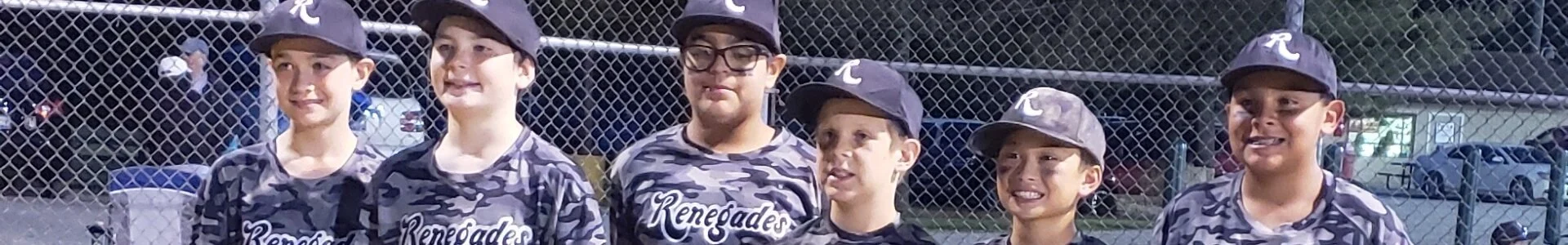 Six young boys in baseball uniforms standing in front of a chain-link fence during a game.