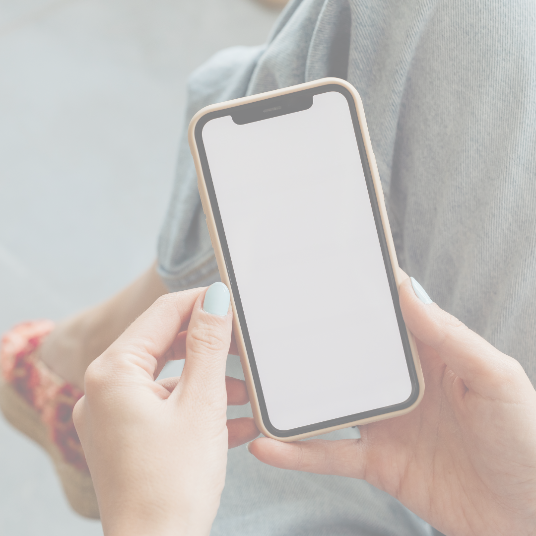 Person holding a smartphone with a blank white screen.