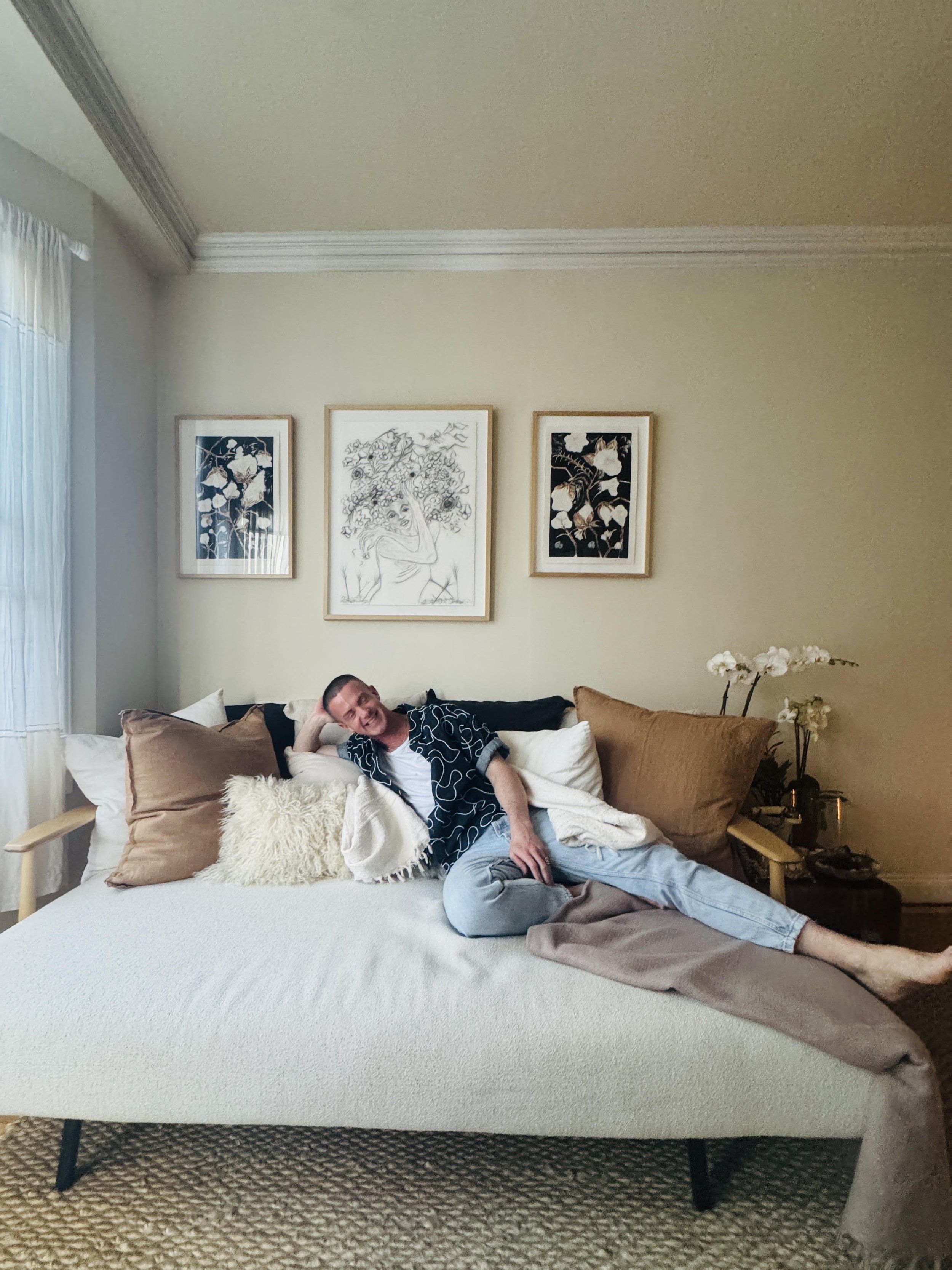 McKay Gordon sits on a couch in a beautifully furnished home, laid back laughing with eyes gently closed.