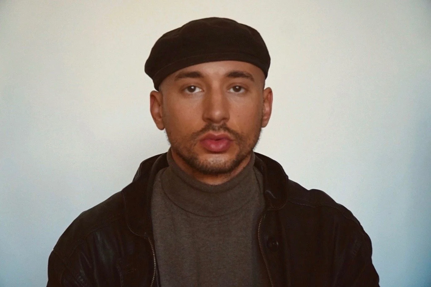 A man wearing a beret against a white background