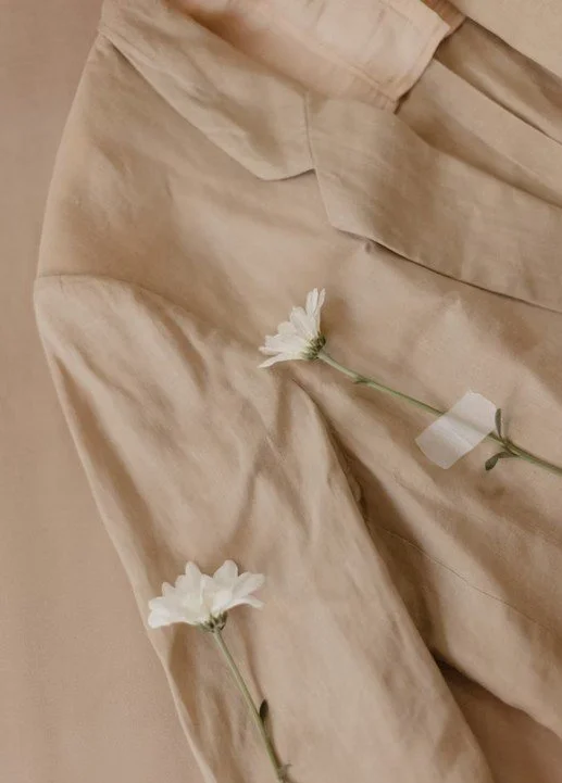 Cremefarbener Stoff mit weißen Blumen.