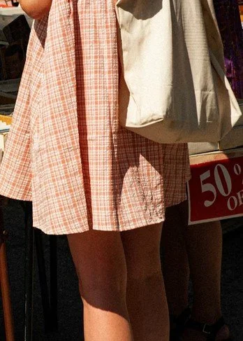 Menschen in Sommerkleidung mit Einkaufstüte auf einem Straßenmarkt