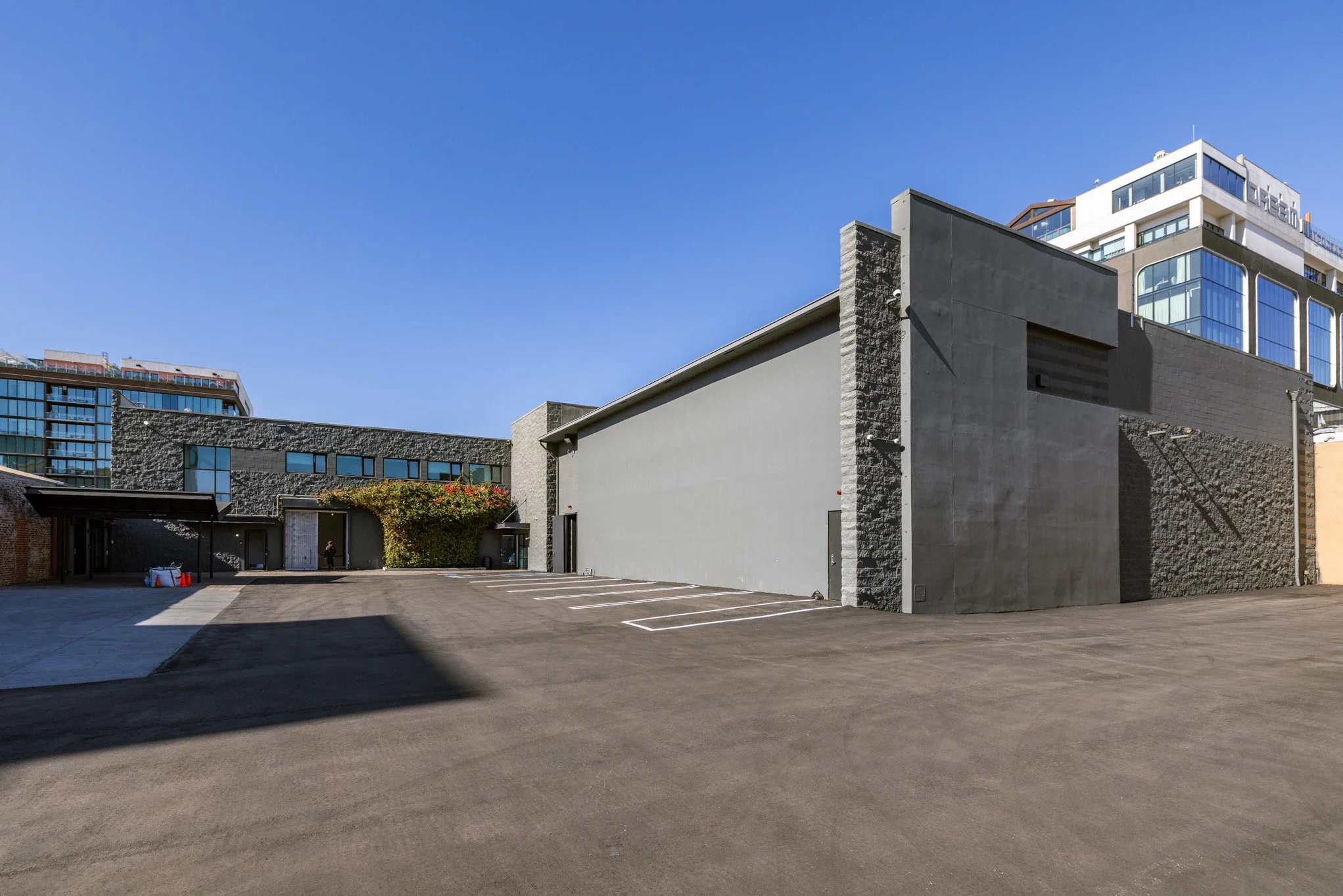Empty parking lot in front of a modern building with a clear blue sky