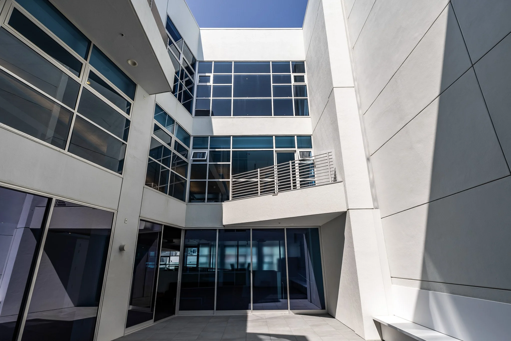 Modern multi-story building with large glass windows and white concrete walls