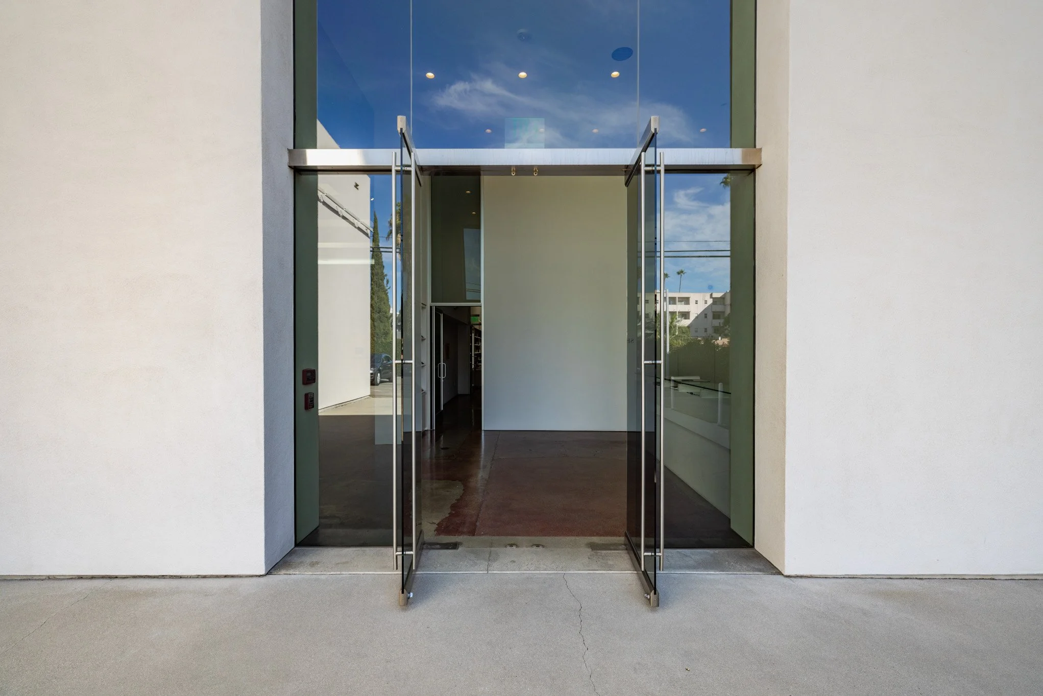 Modern building entrance with glass double doors and white exterior wall