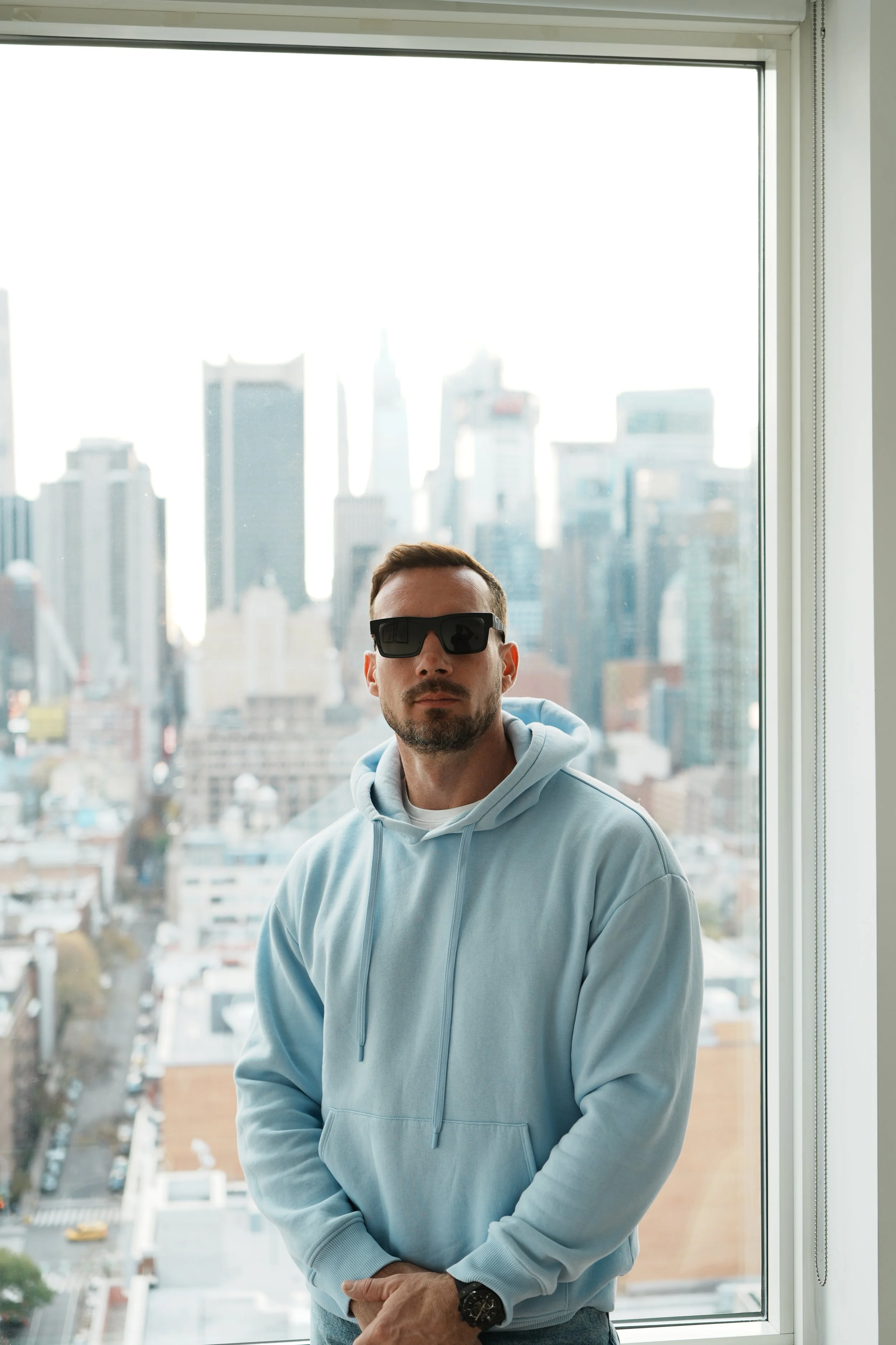 Jérôme devant une fenêtre avec vue sur New York