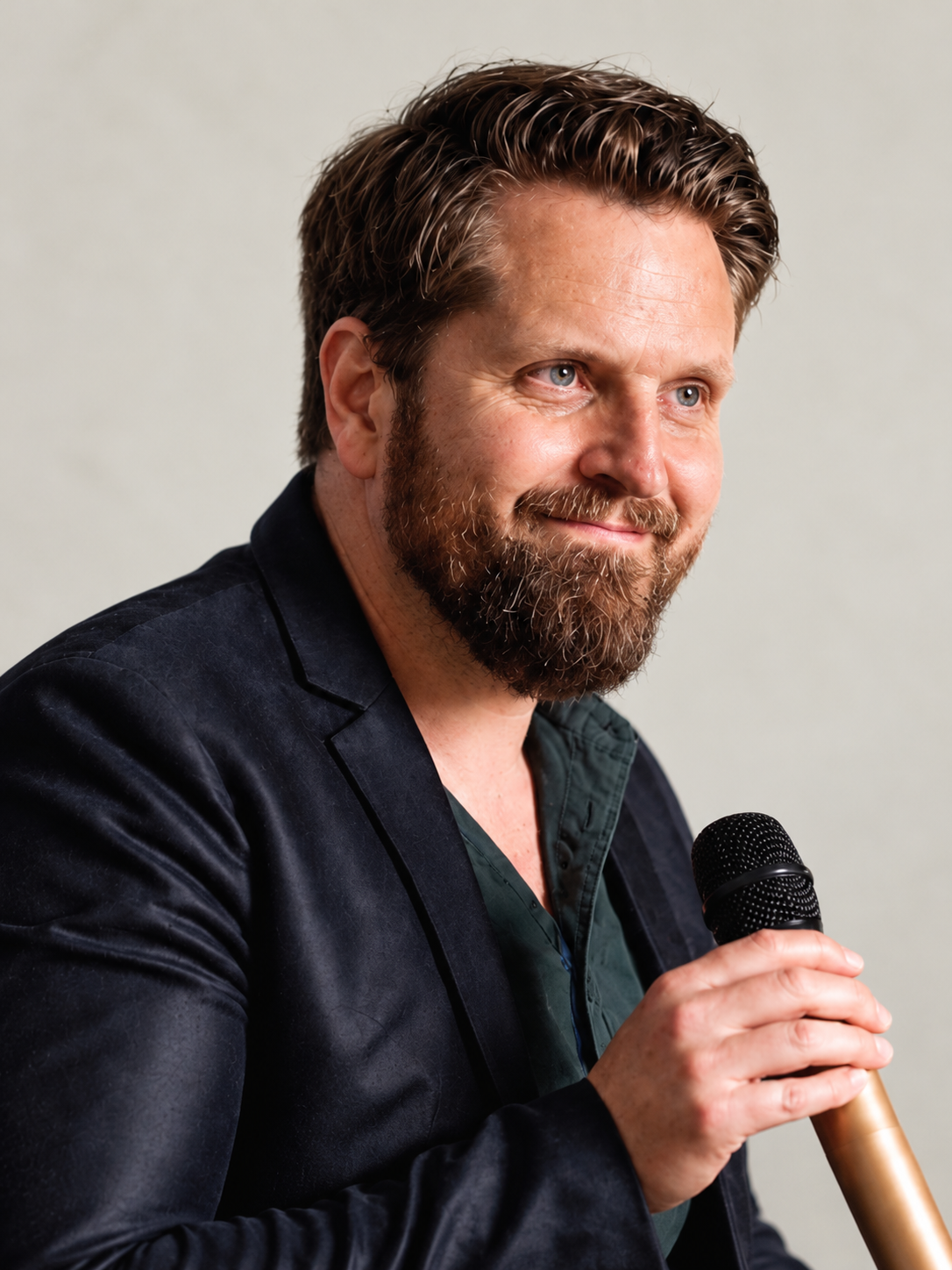Close-up of Mikkel Becker-Aakervik wearing a blue shirt, outdoors with blurred greenery background.