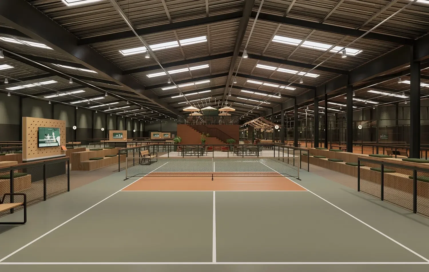 Indoor tennis court with net, seating on sides, LED lighting, and high ceiling with skylights and fans.
