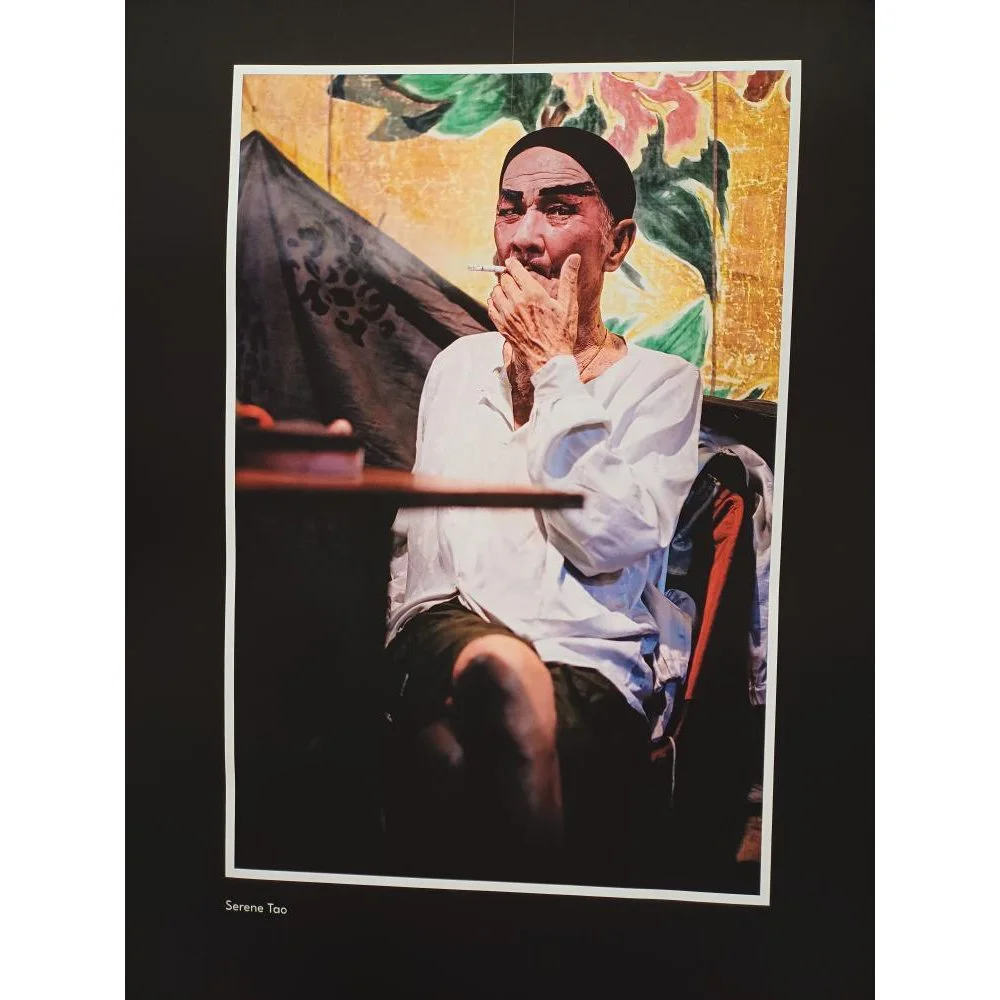 Documentary photograph of a Chinese opera performer taking a rest after a performance, captured in a calm, observational style.