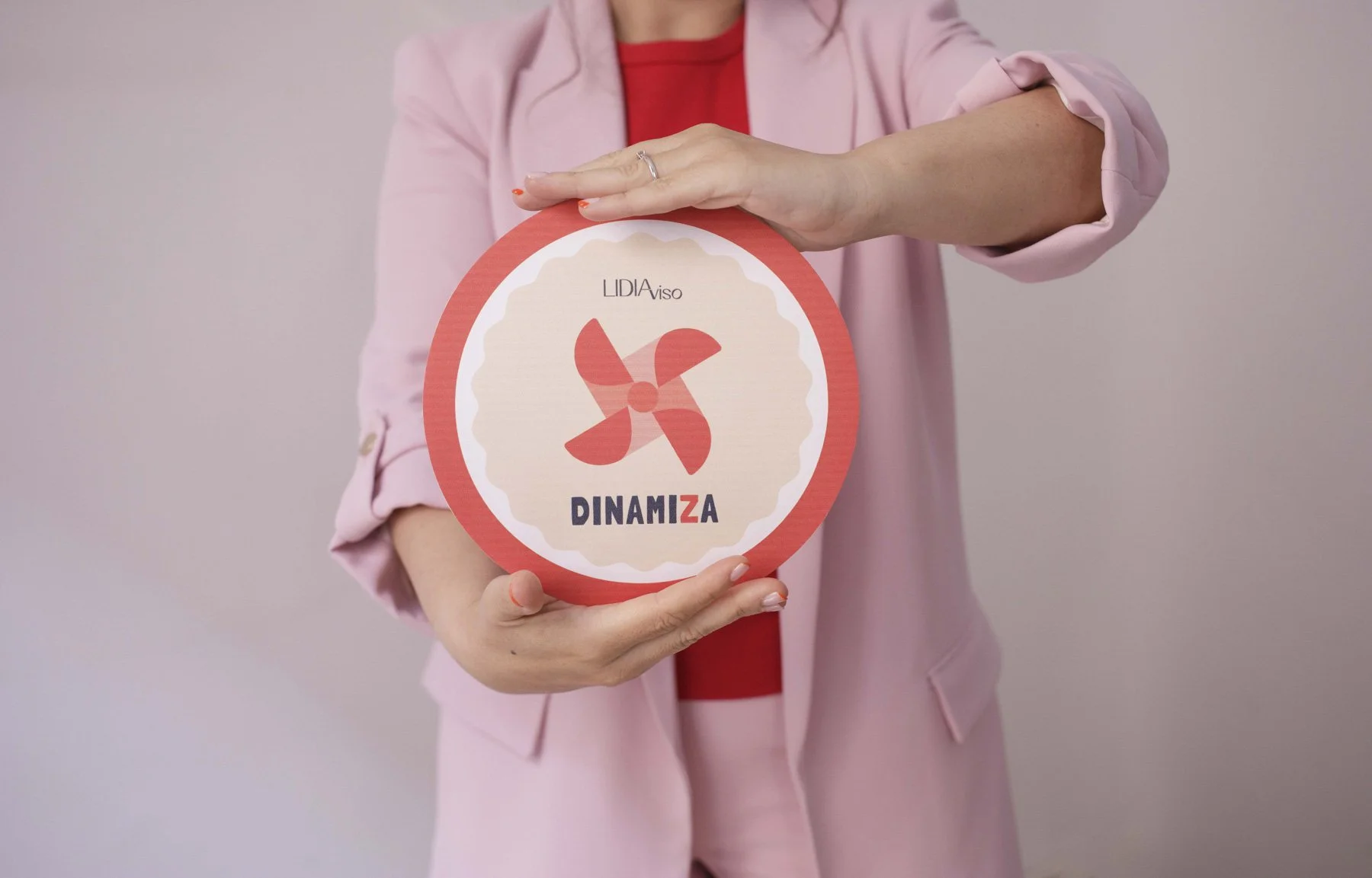 Lidia Viso sosteniendo un cartel redondo con el logo de LIDIA y el texto 'Dinamiza'.