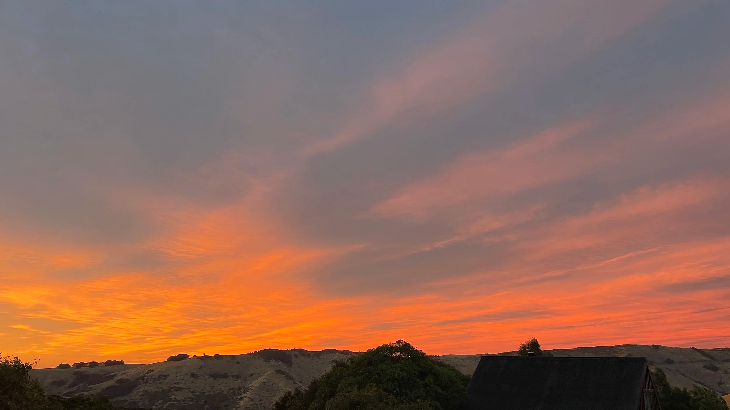 A glowing orange sunset over ranging hills