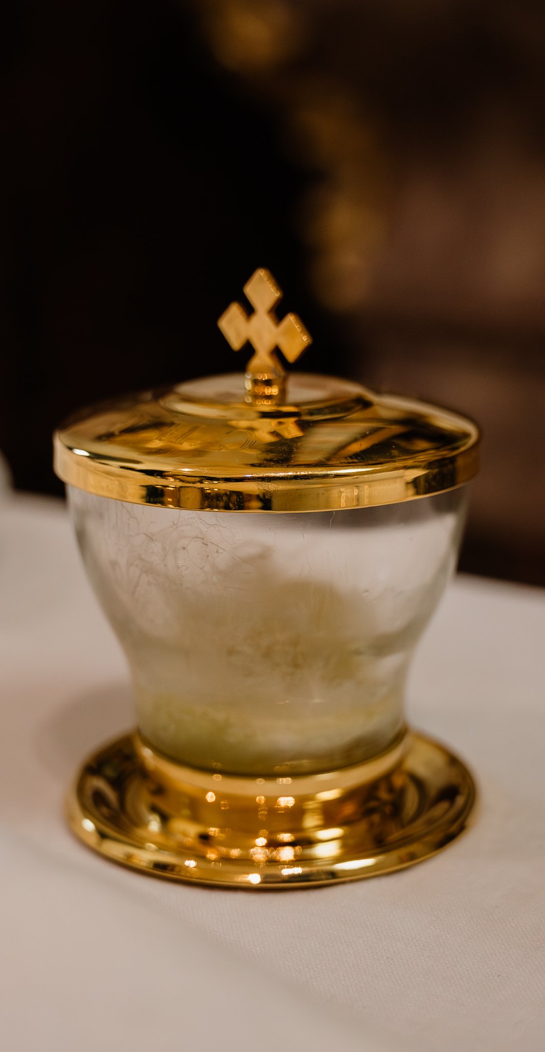 Goldene Kiste mit Kreuzsymbol auf dem Deckel auf weißem Tuch
