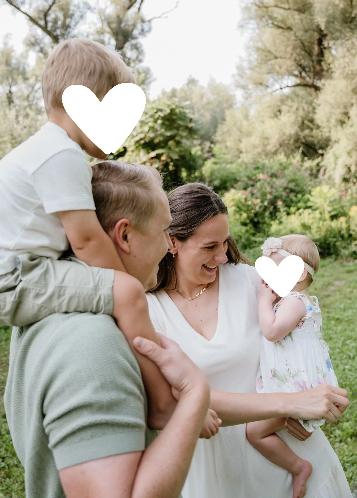 Eine Familie im Park, bestehend aus einem Mann, einer Frau, einem Jungen und einem Mädchen, die lachen und Spaß haben.