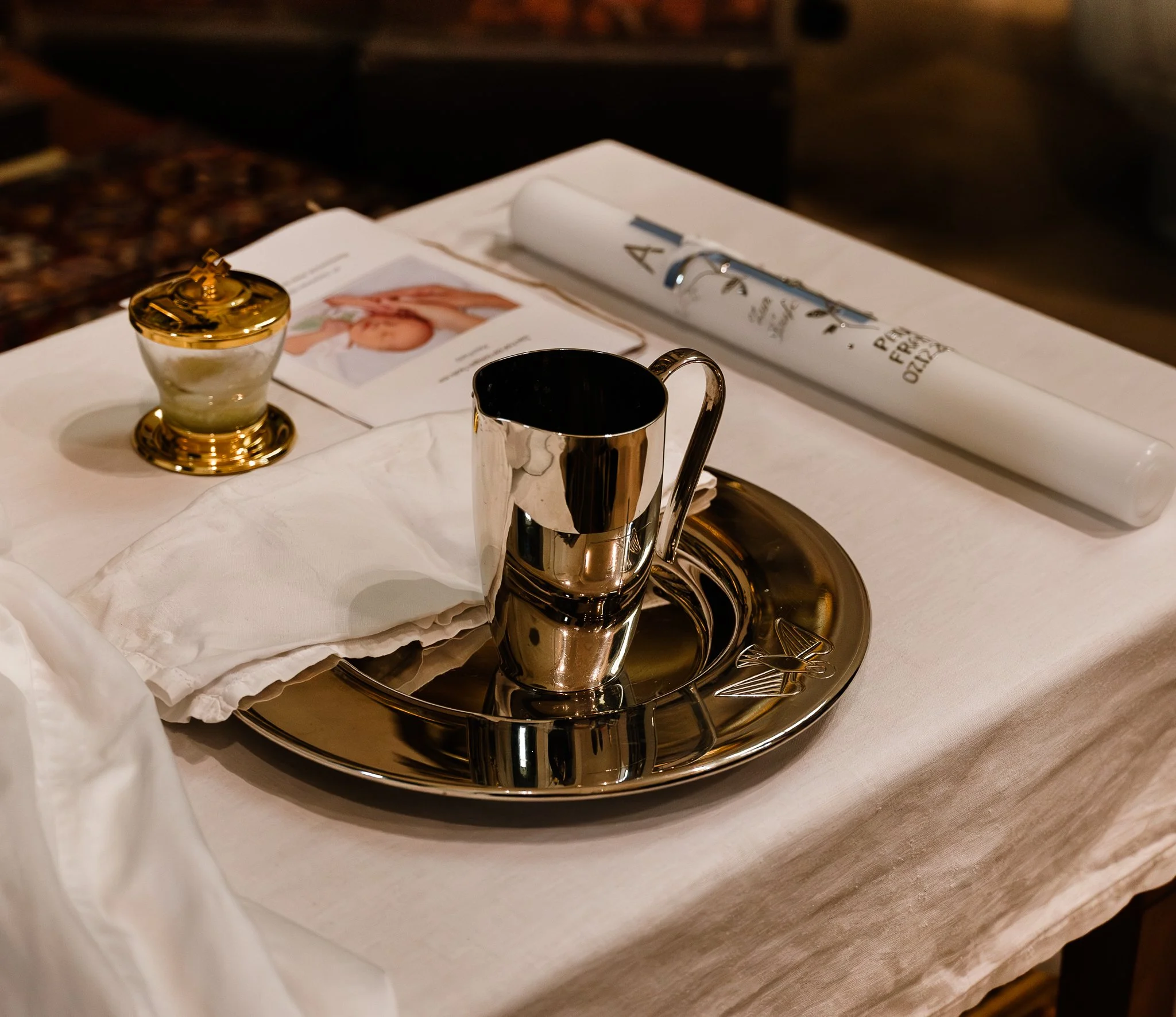 Tisch mit silberner Tasse, einem weißen Laken, einem Goldwäschkonzept, zerknittertem weißen Taschentuch, einer flachen Kompott, einem Magazin und einer abgerollten Zeitung