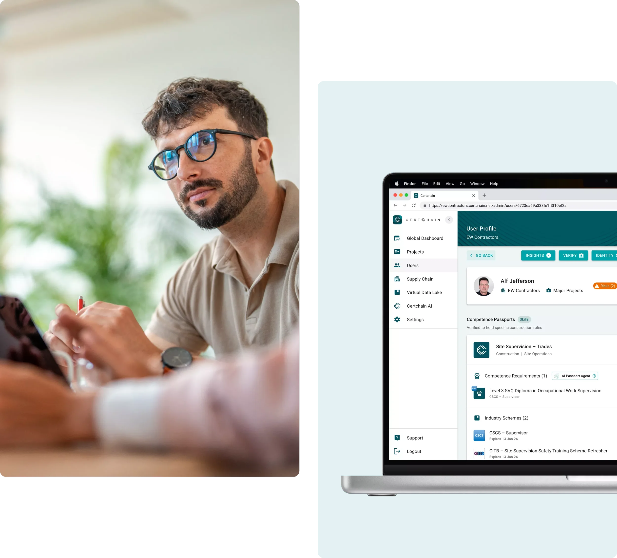 A man with glasses and a beard sitting at a desk, looking to the side, with a tablet in his hand. There is a computer screen showing a user profile on the right side with various project and skill details.